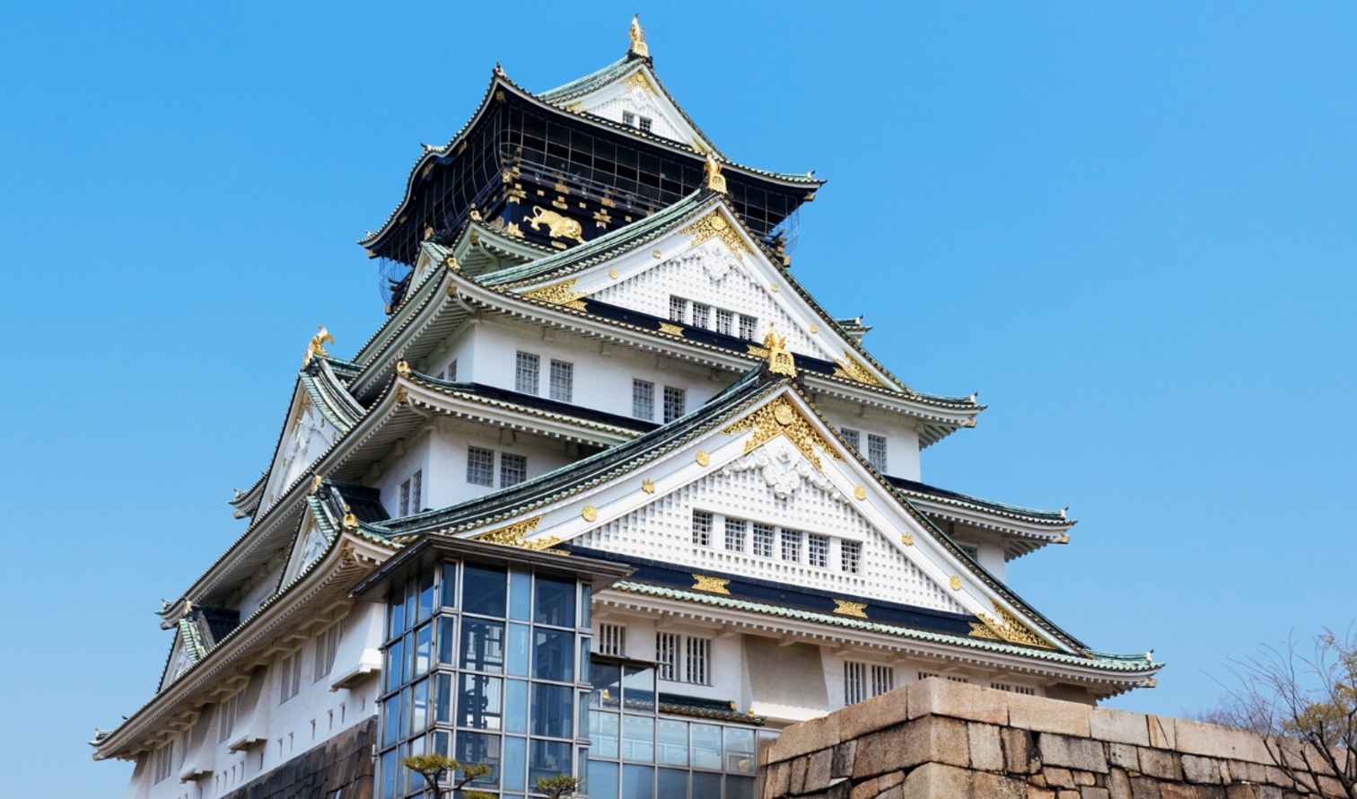 Osaka Castle against a clear blue sky.