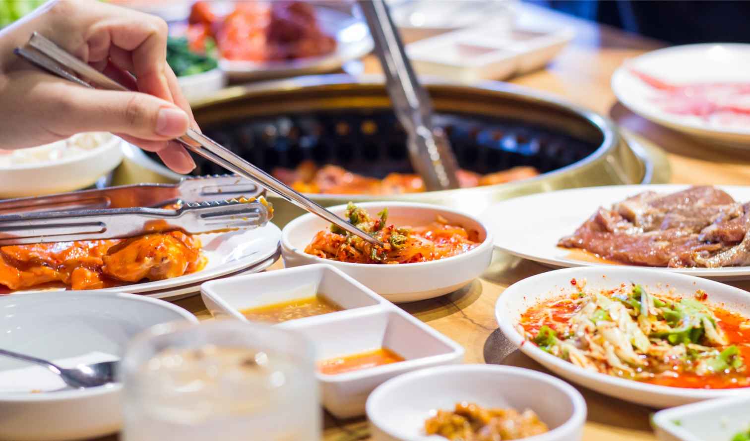 Close-up of a person preparing Korean barbecue at a restaurant in Seoul