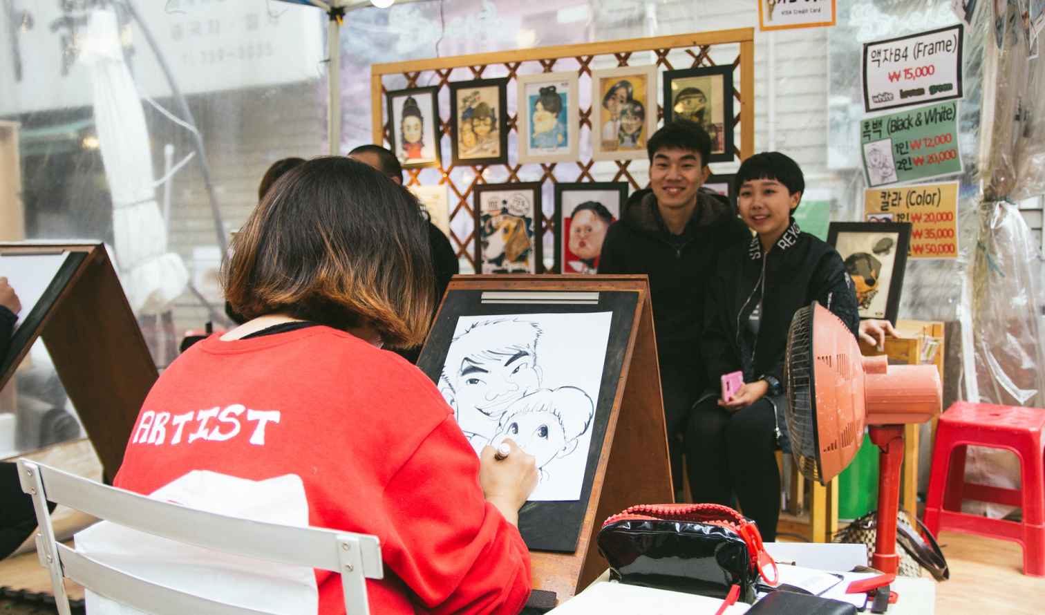 Artist drawing caricatures in a street market in Seoul, South Korea.