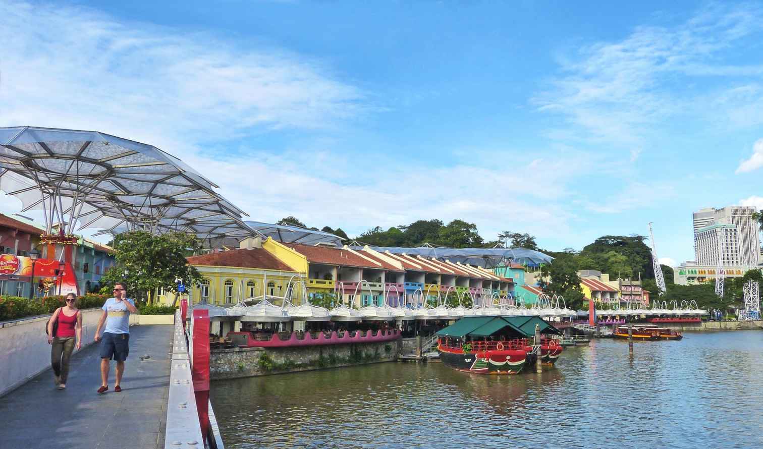 Two people walking on a bridge at Clarke Quay, Singapore.