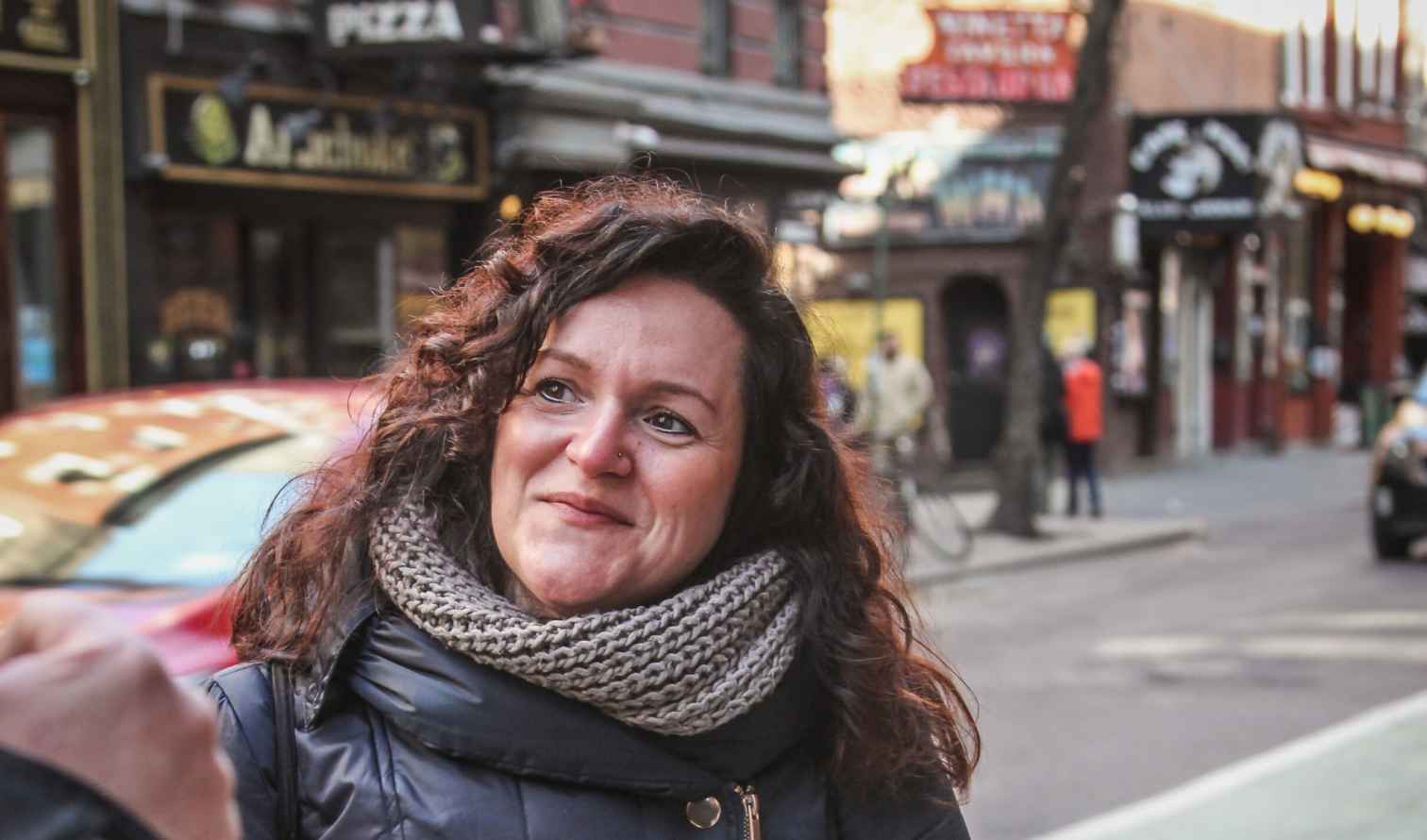 Woman in a blue coat on a busy urban street in New York