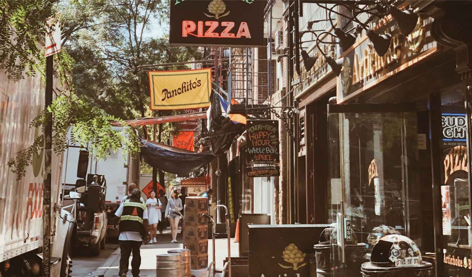 Street view with Artichoke Pizza and Panchito's signs in Greenwich Village, New York.