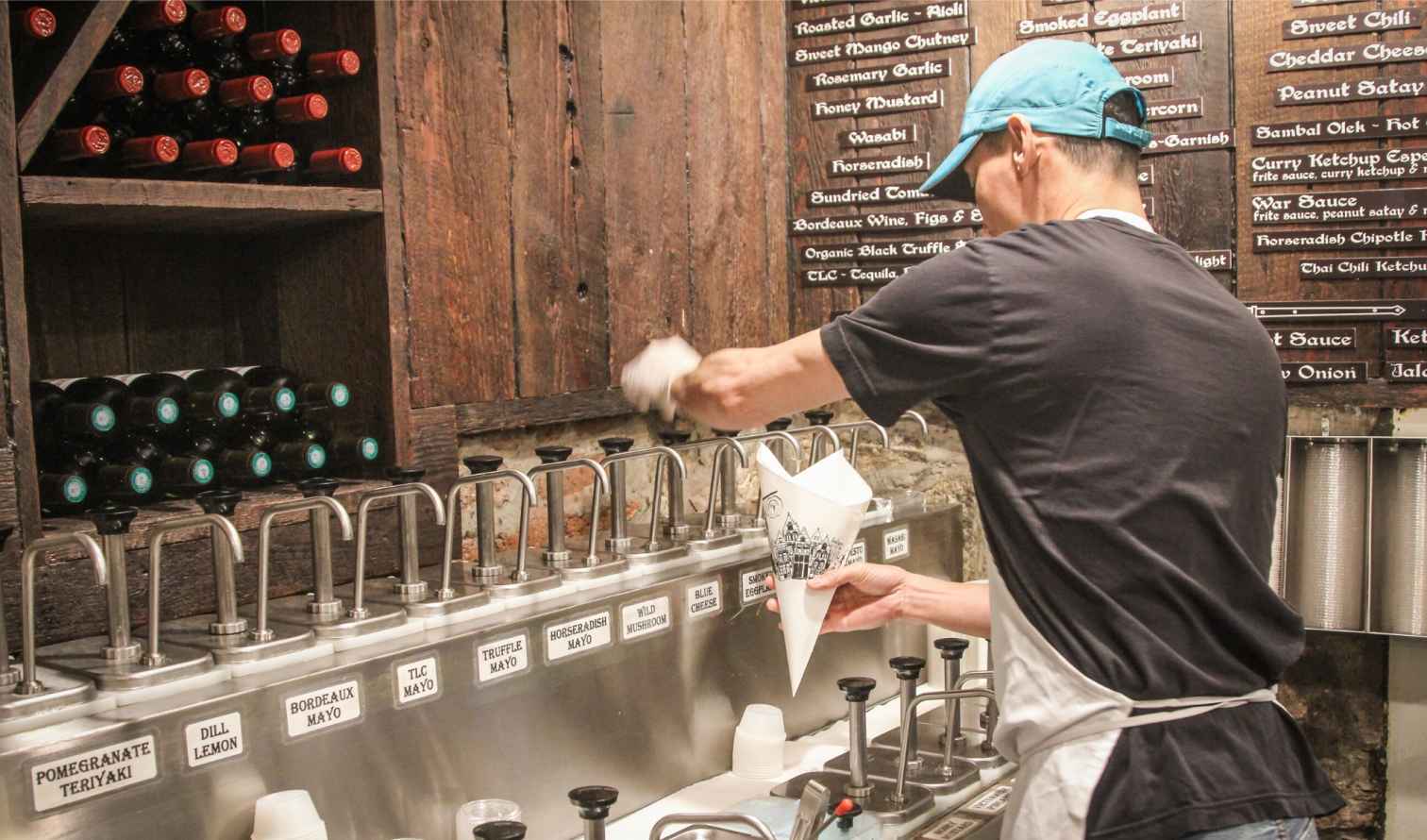 A person serves sauces at Pommes Frites in New York City.