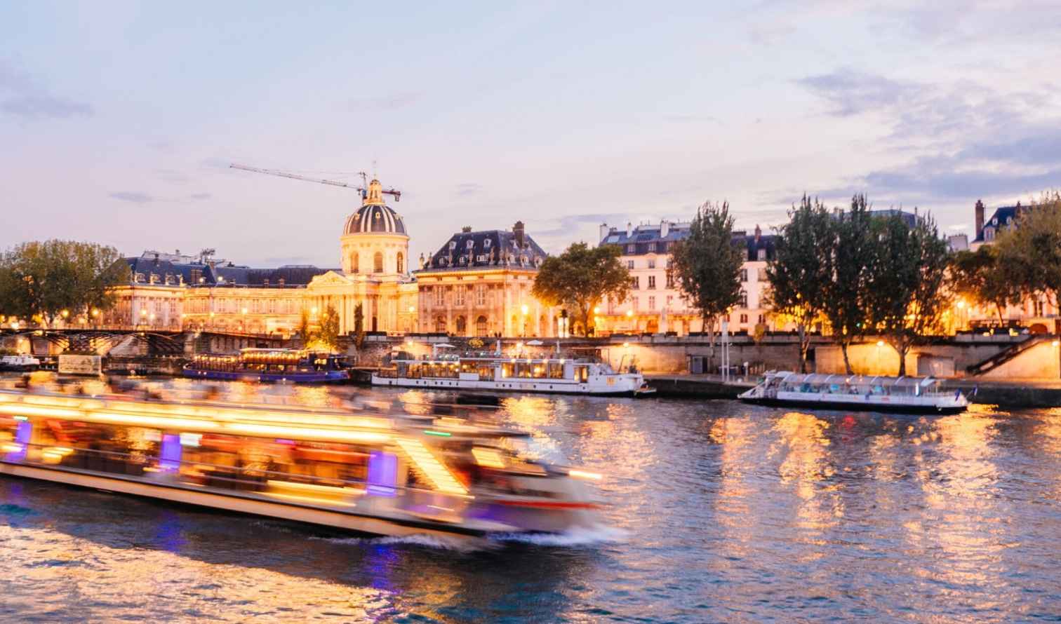 Pont des Arts bridge crossing the Seine with a boat in Paris.
