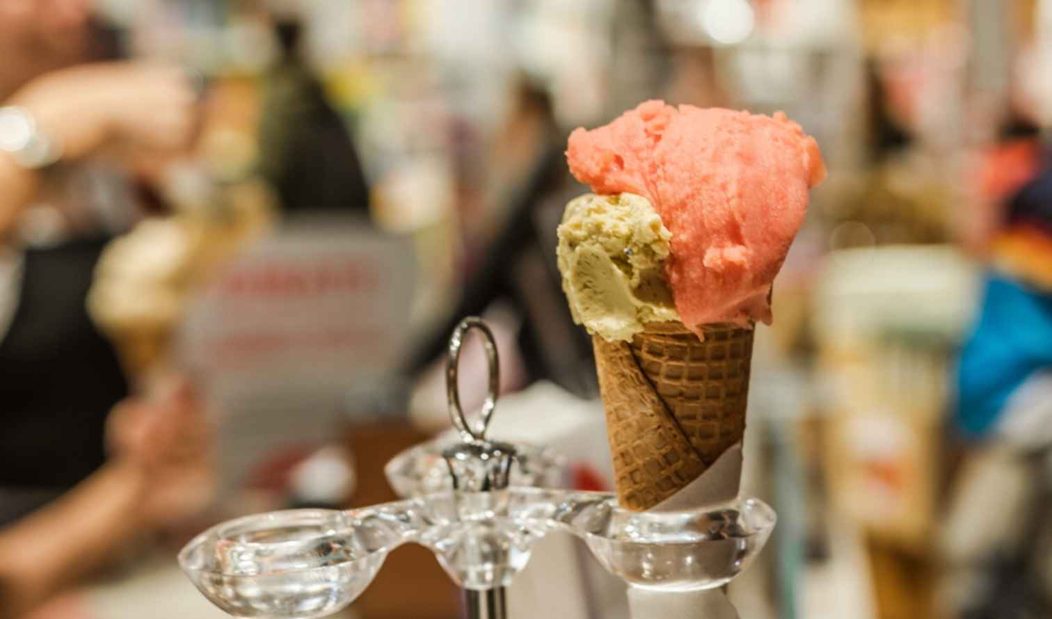 Ice cream cone with two flavors on a metal stand in a shop in Milan