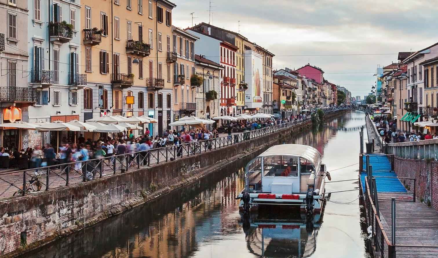 View of Naviglio Grande canal in Milan with a boat and old buildings.