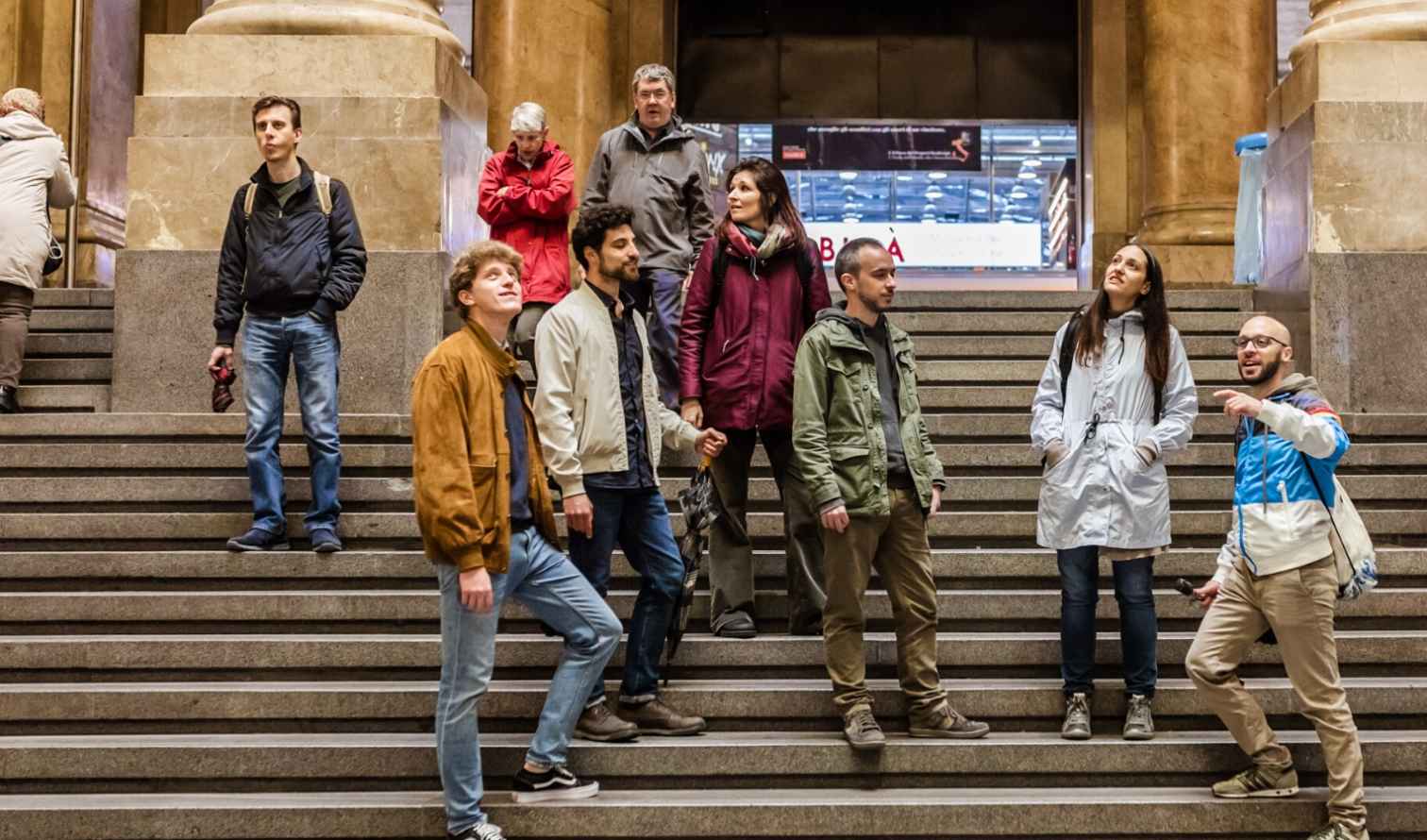 Group of tourists on steps of a large stone stairway in Milan