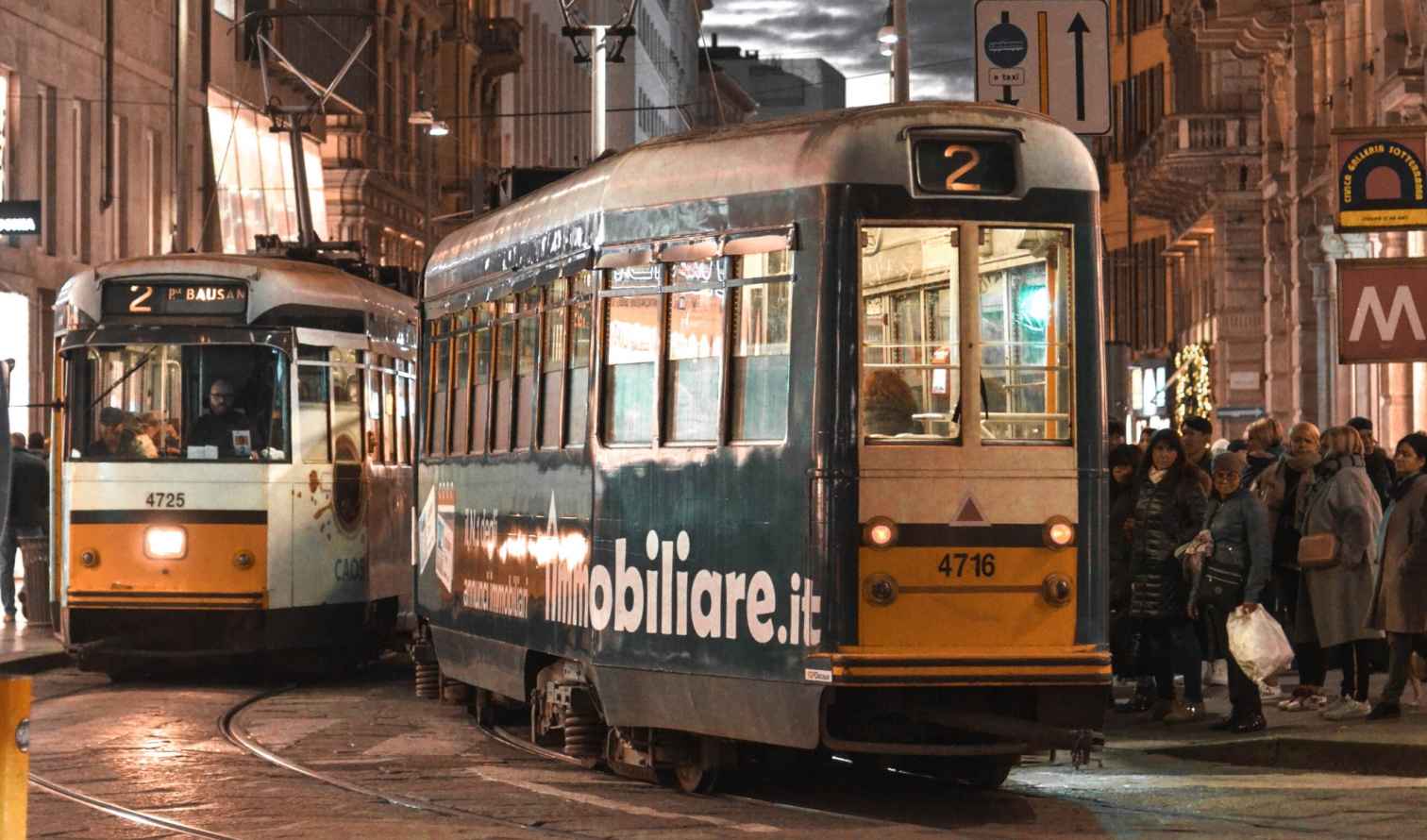 Trams in transit on Via Torino, Milan at night.