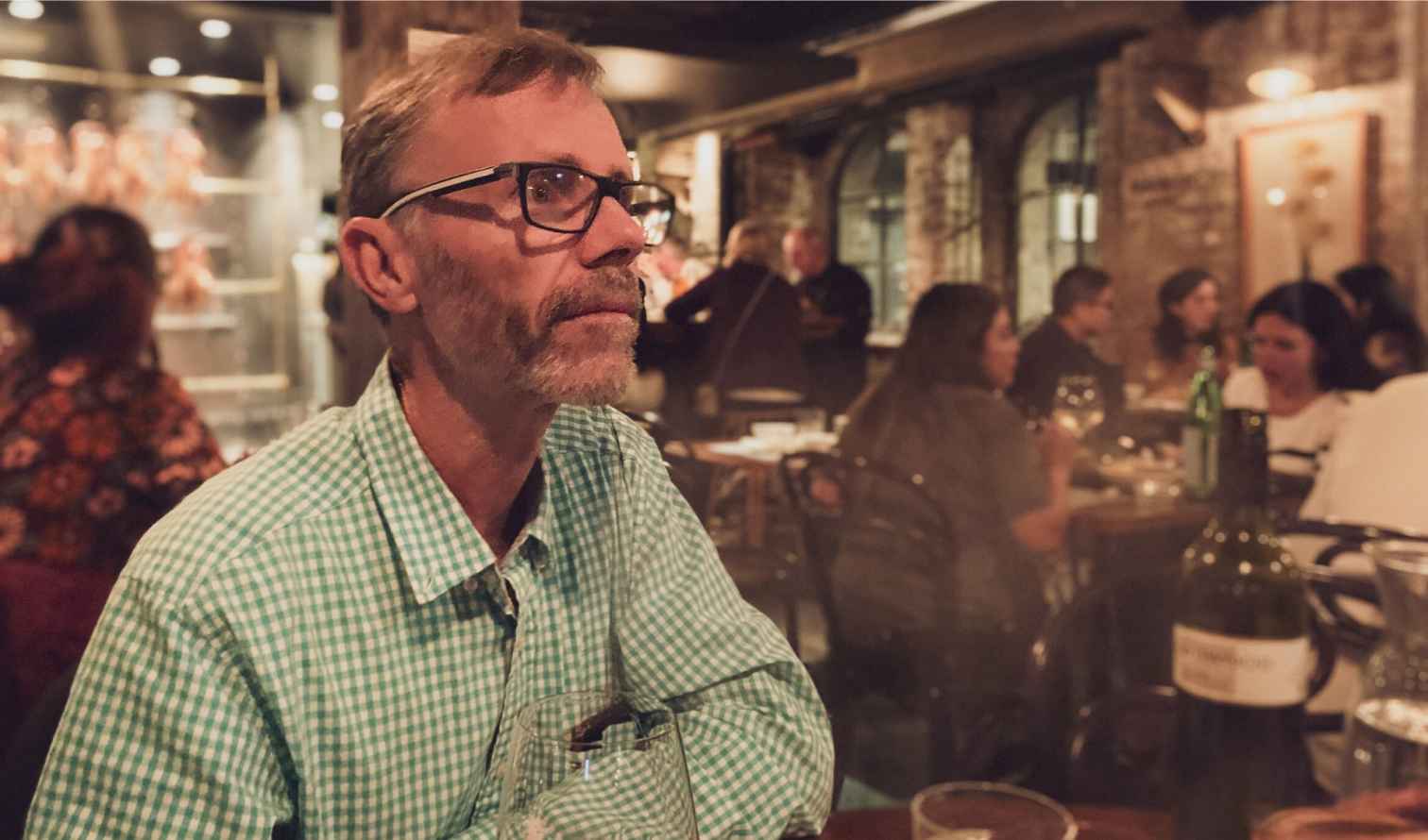 Man in glasses at a restaurant with exposed brick walls  in Sydney