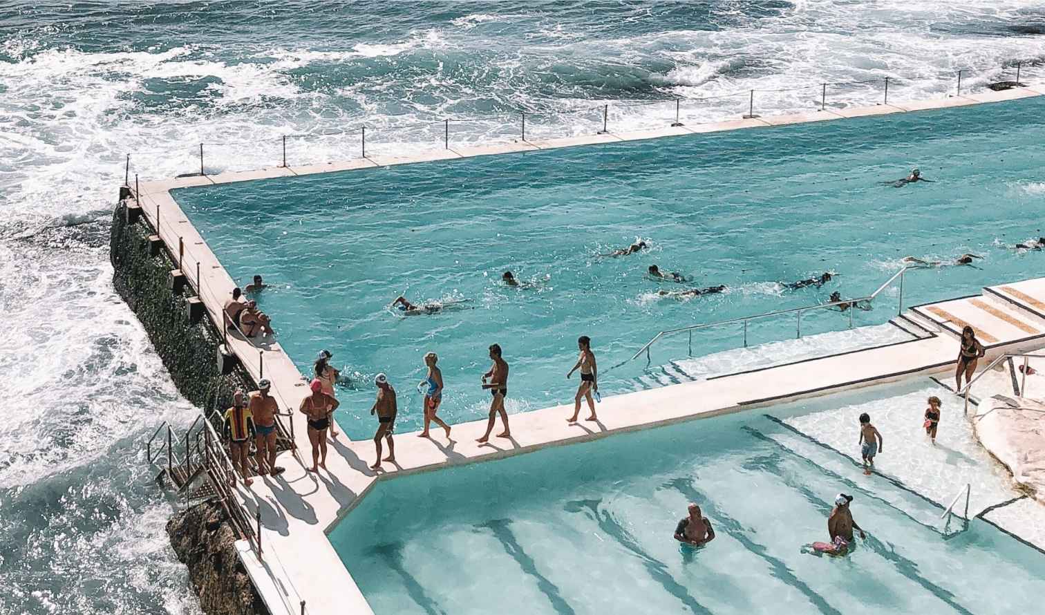 People swimming at Bondi Icebergs Club, overlooking the ocean.