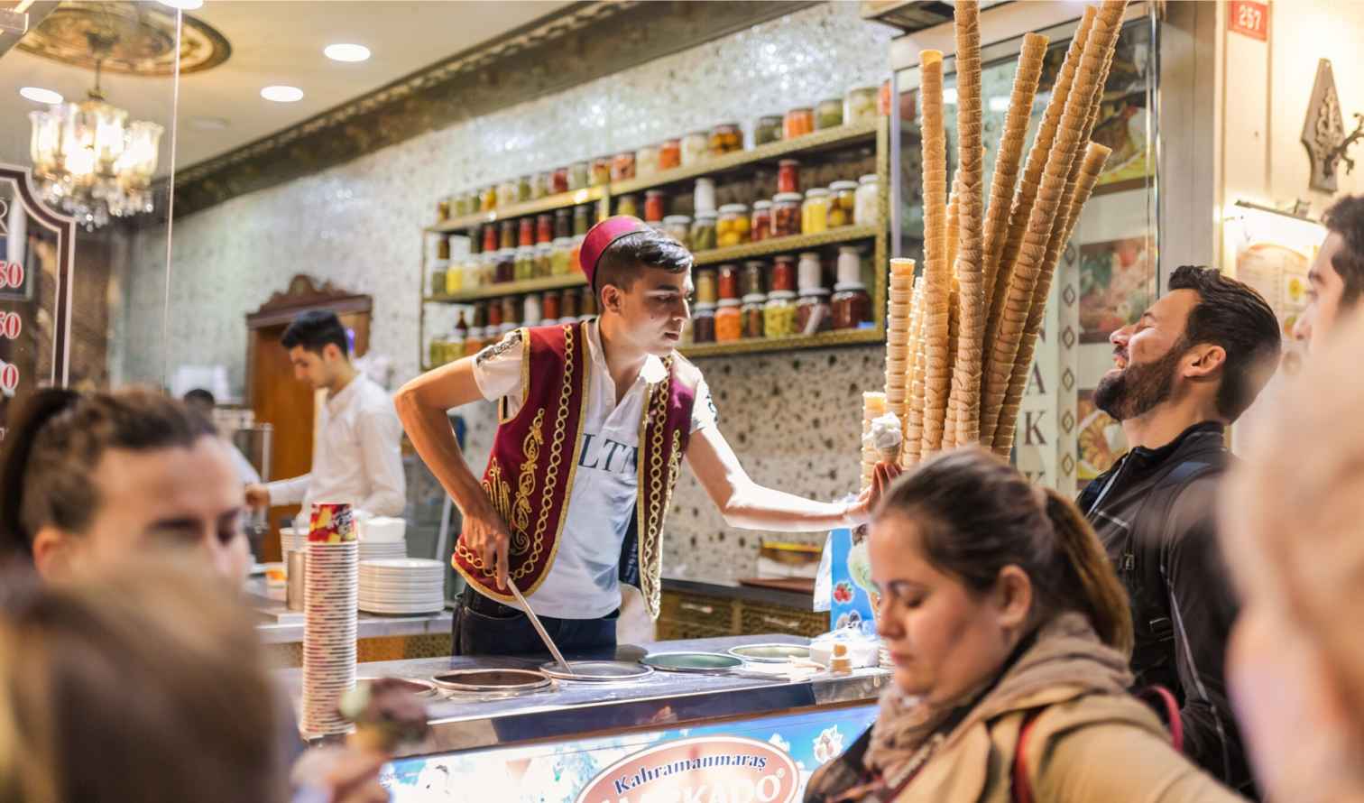 Customers watching a street vendor's ice cream performance in Istanbul.