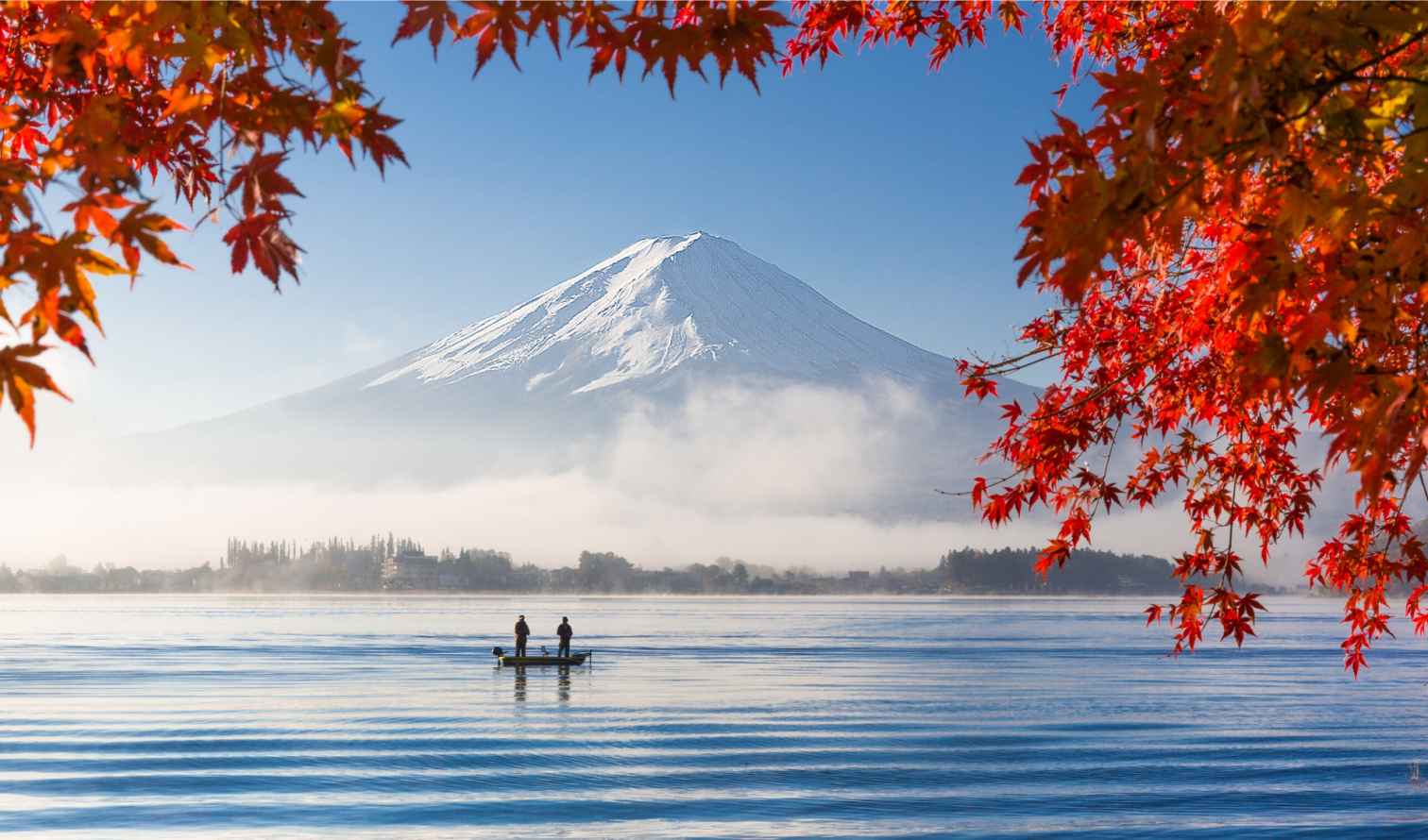 Two people in a boat on a lake with Mount Fuji in the background in Kawaguchi-ko