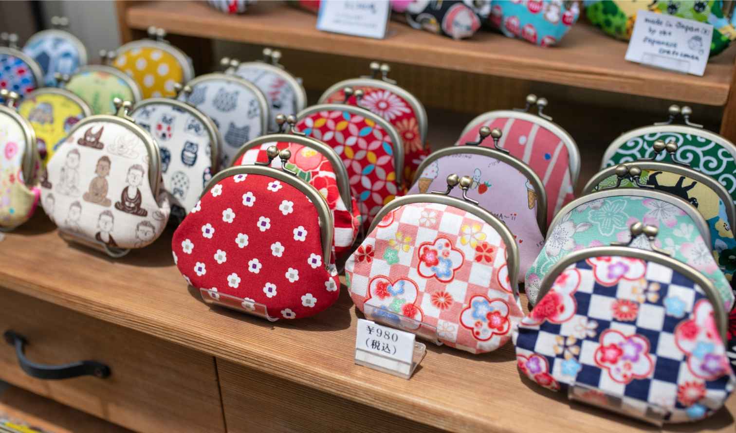 Colorful coin purses displayed on a wooden shelf  in Kamakura, in Japan.