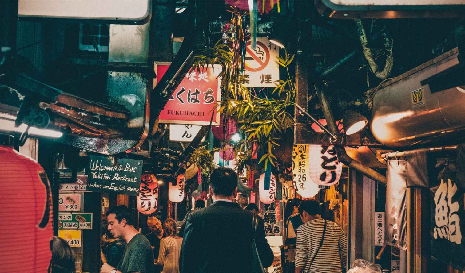 Narrow street in Omoide Yokocho, Tokyo lined with red lanterns.