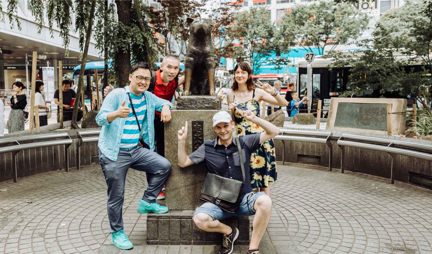 Group posing by Hachiko statue in Shibuya, Tokyo.
