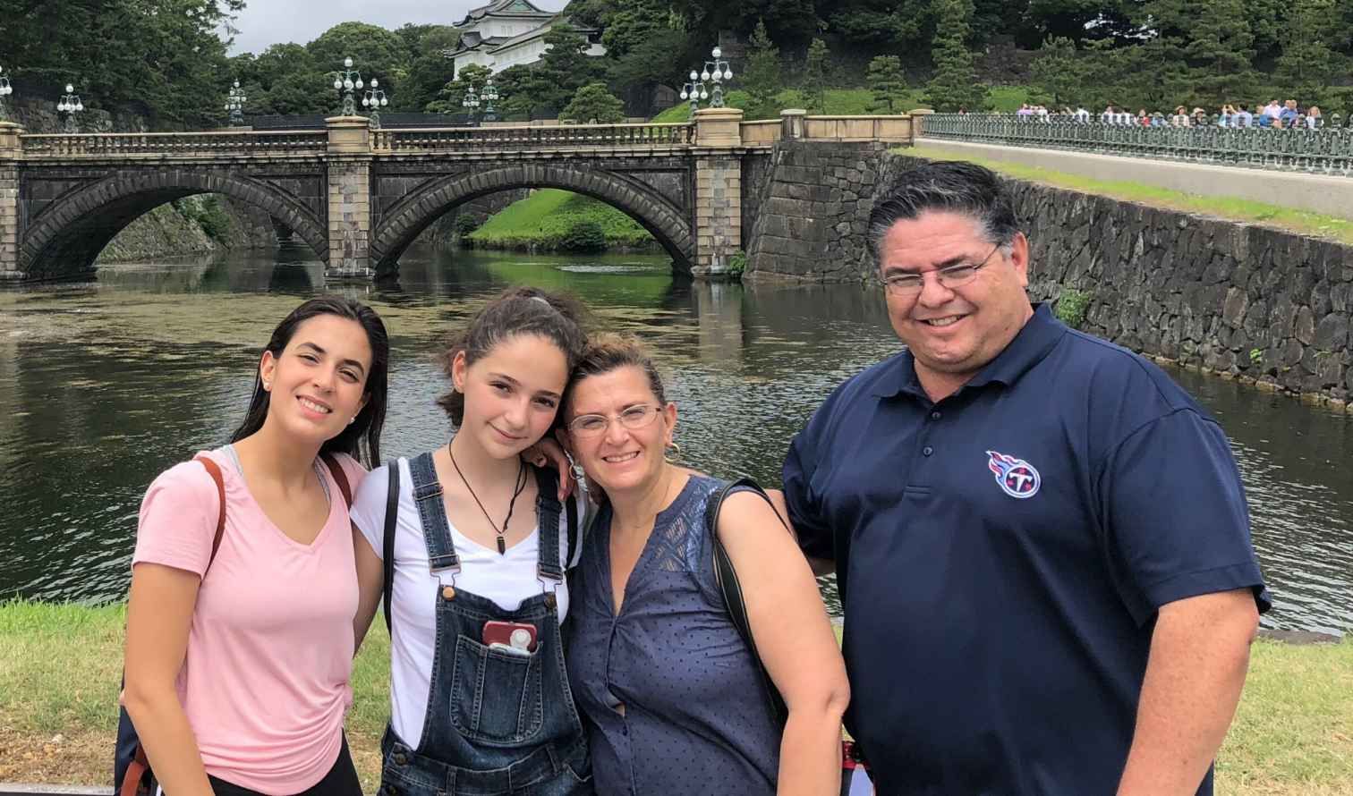 A family stands in front of the Imperial Palace bridge in Tokyo, Japan.