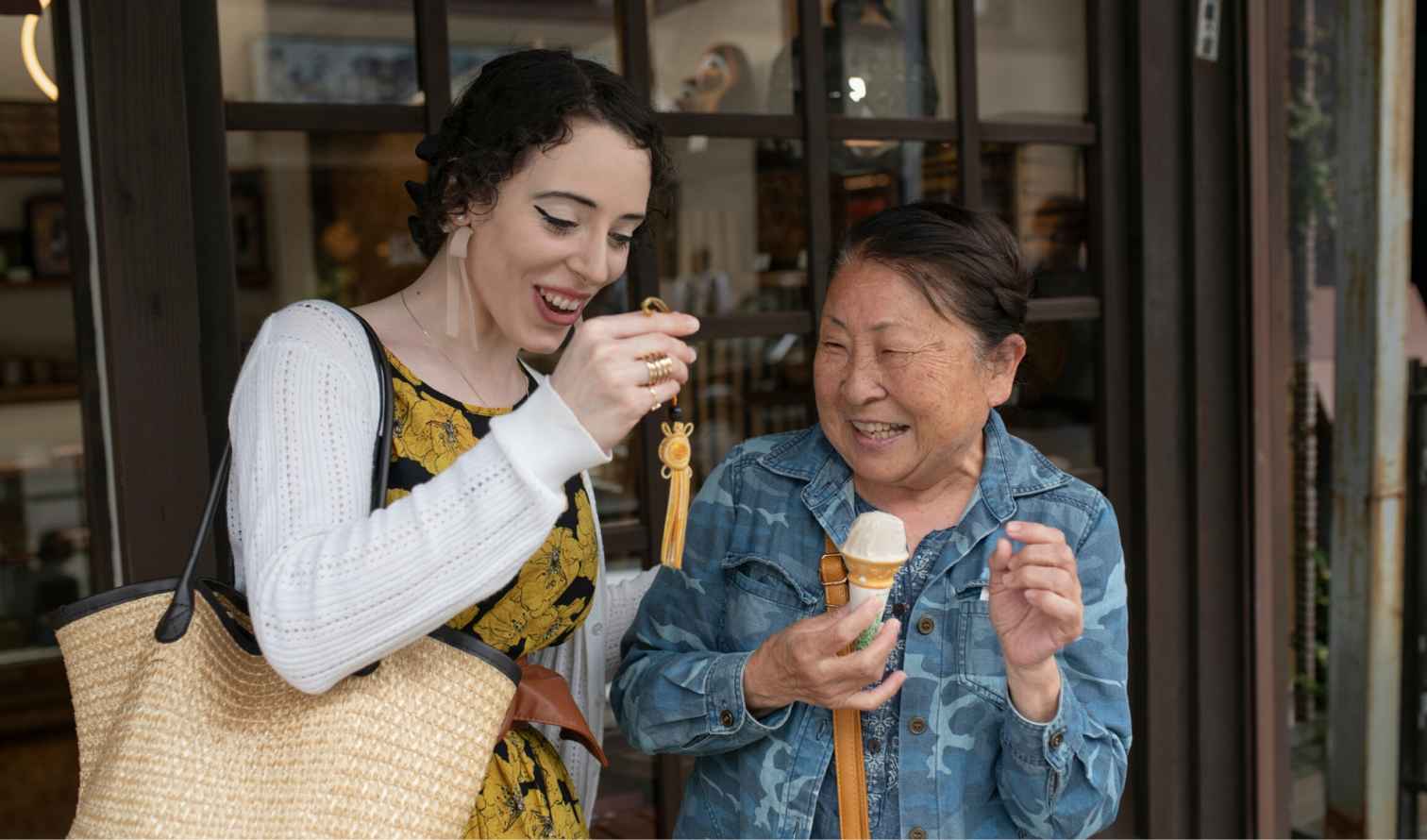 Two women standing outside a shop, one holding an ice cream cone in Tokyo