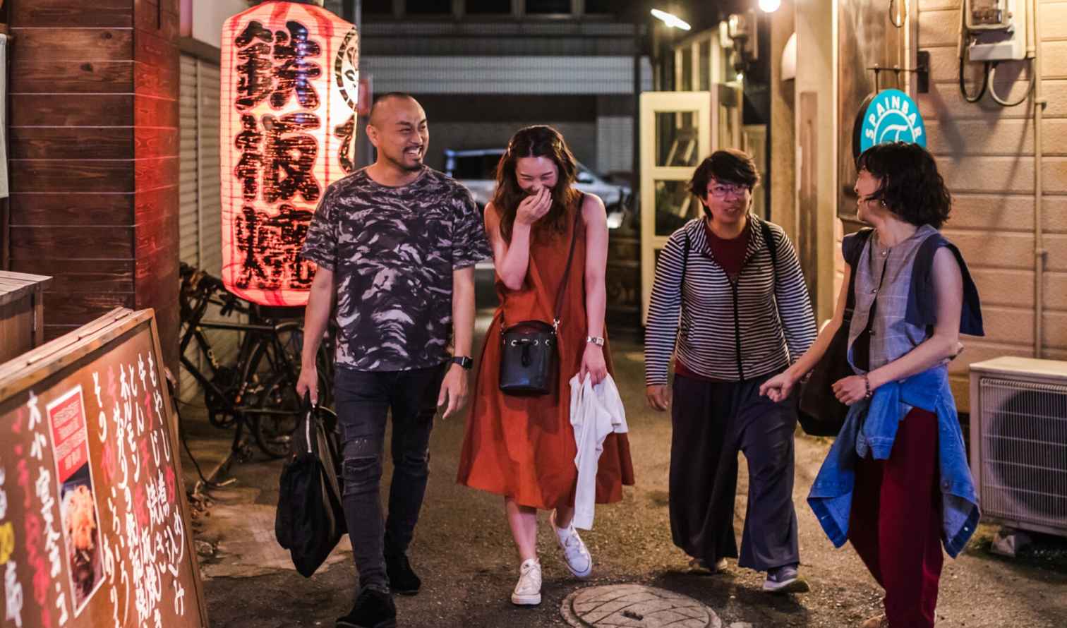 Group of people walking through an alley with a large Japanese lantern in Fukuoka
