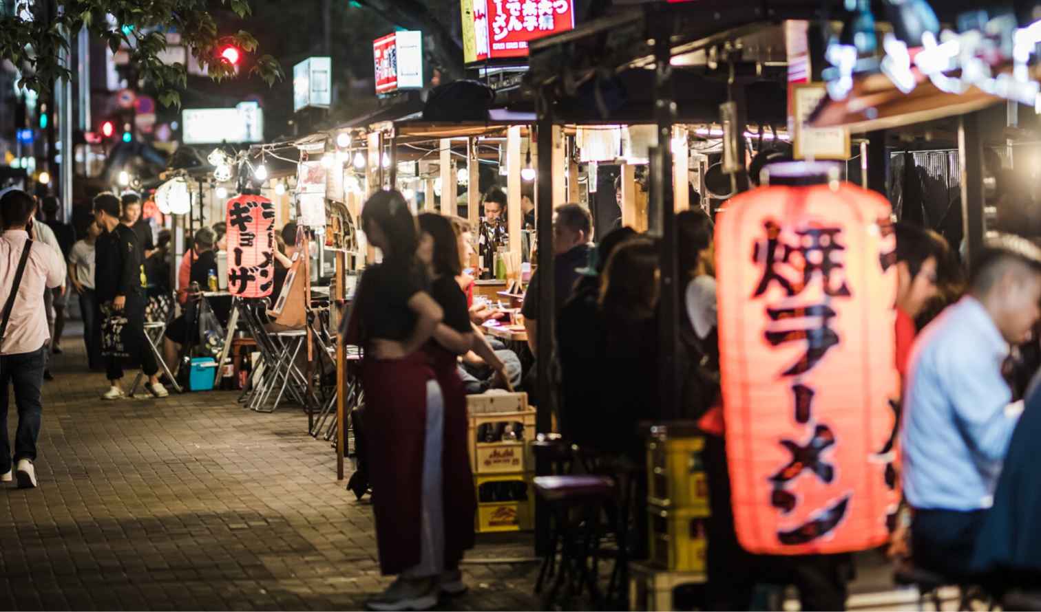 Street food stalls with people dining at night in Fukuoka, Japan.