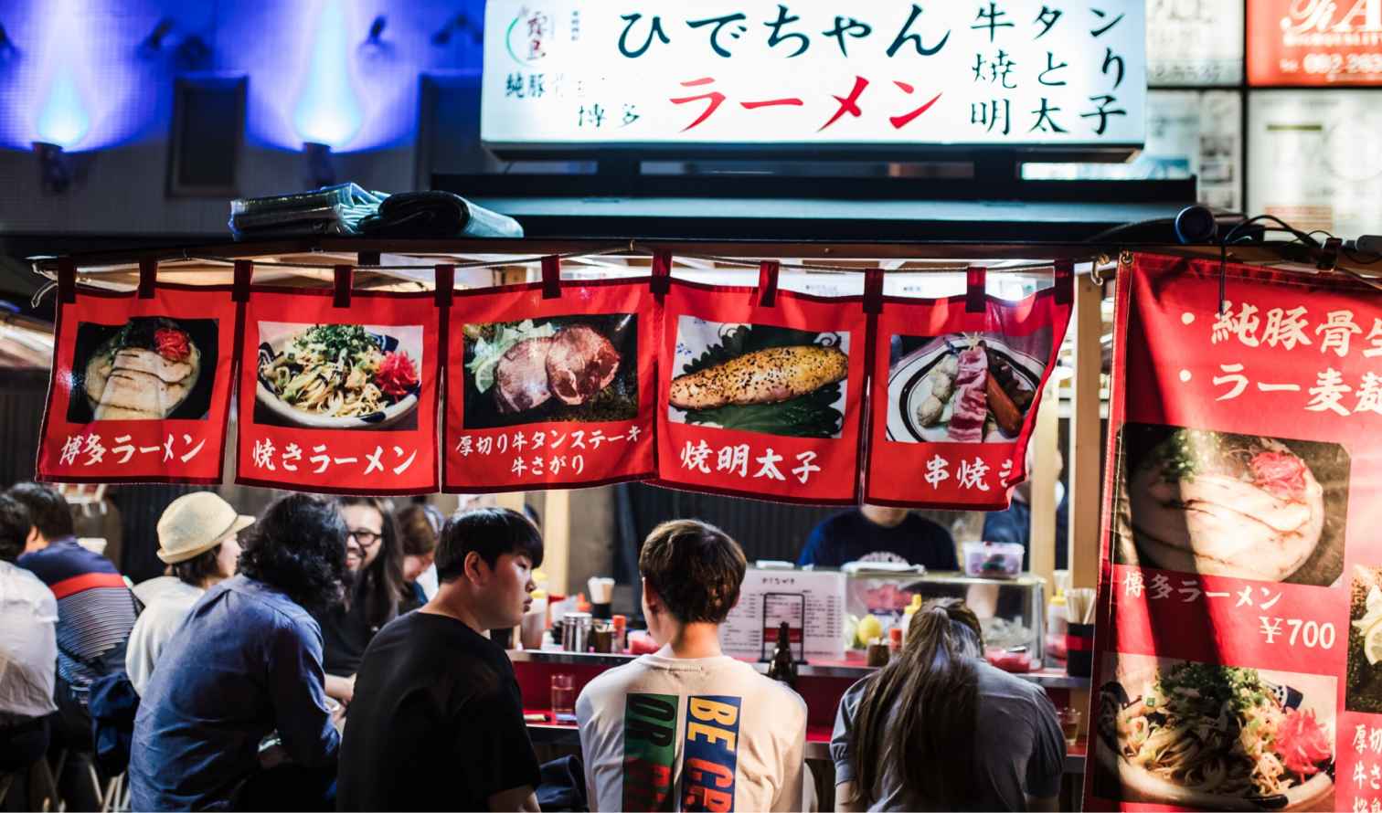 Group eating at a traditional ramen yatai in Fukuoka