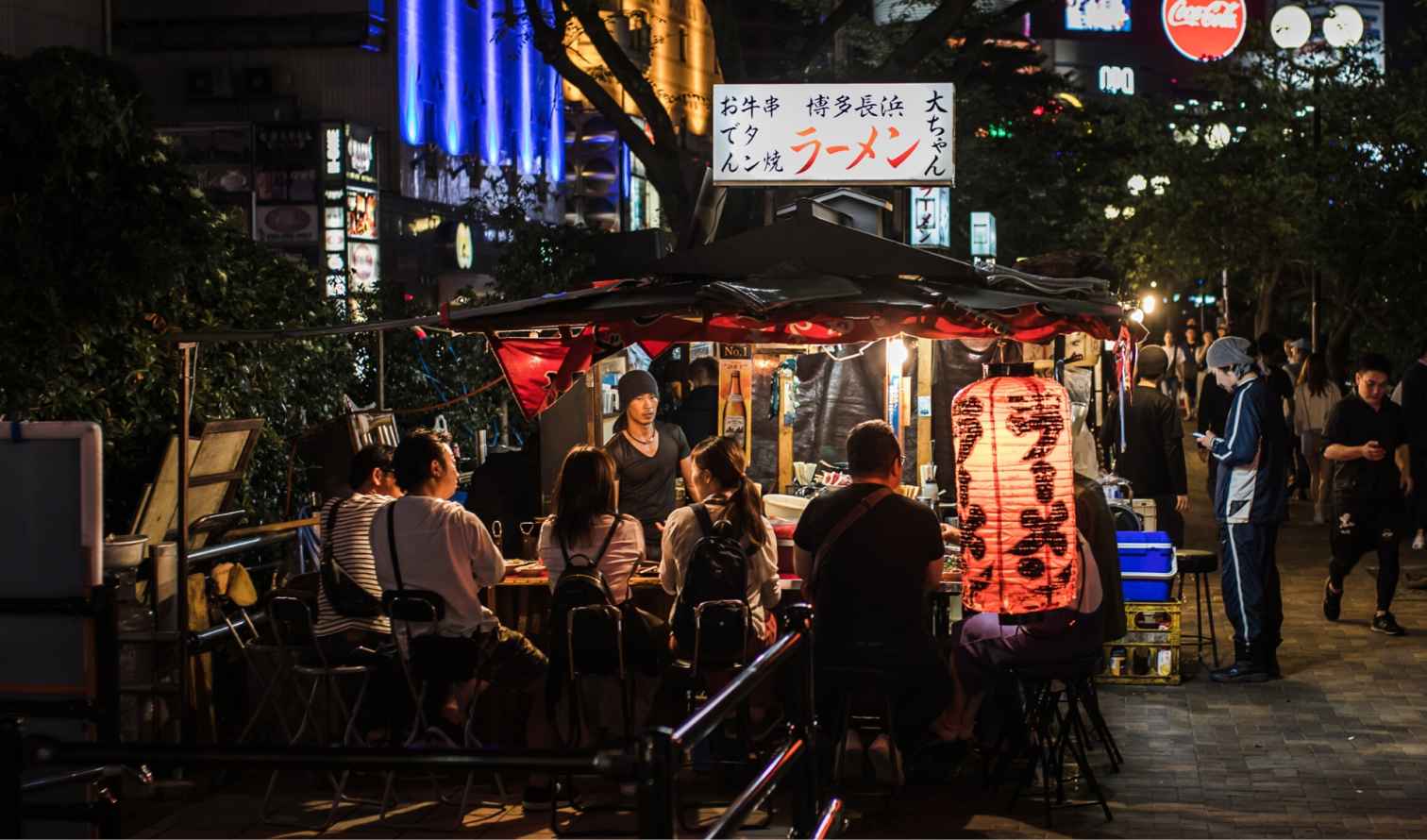 Street food stall in Fukuoka, Japan with a group of people seated.
