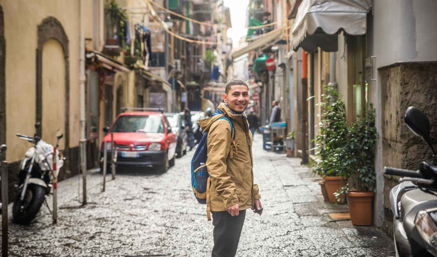 Person walking on a narrow street in Naples, Italy.