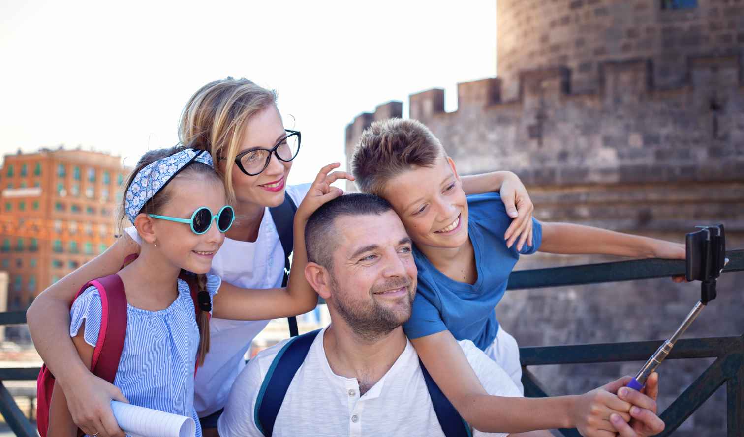 Family taking selfie near a historical stone tower in Naples