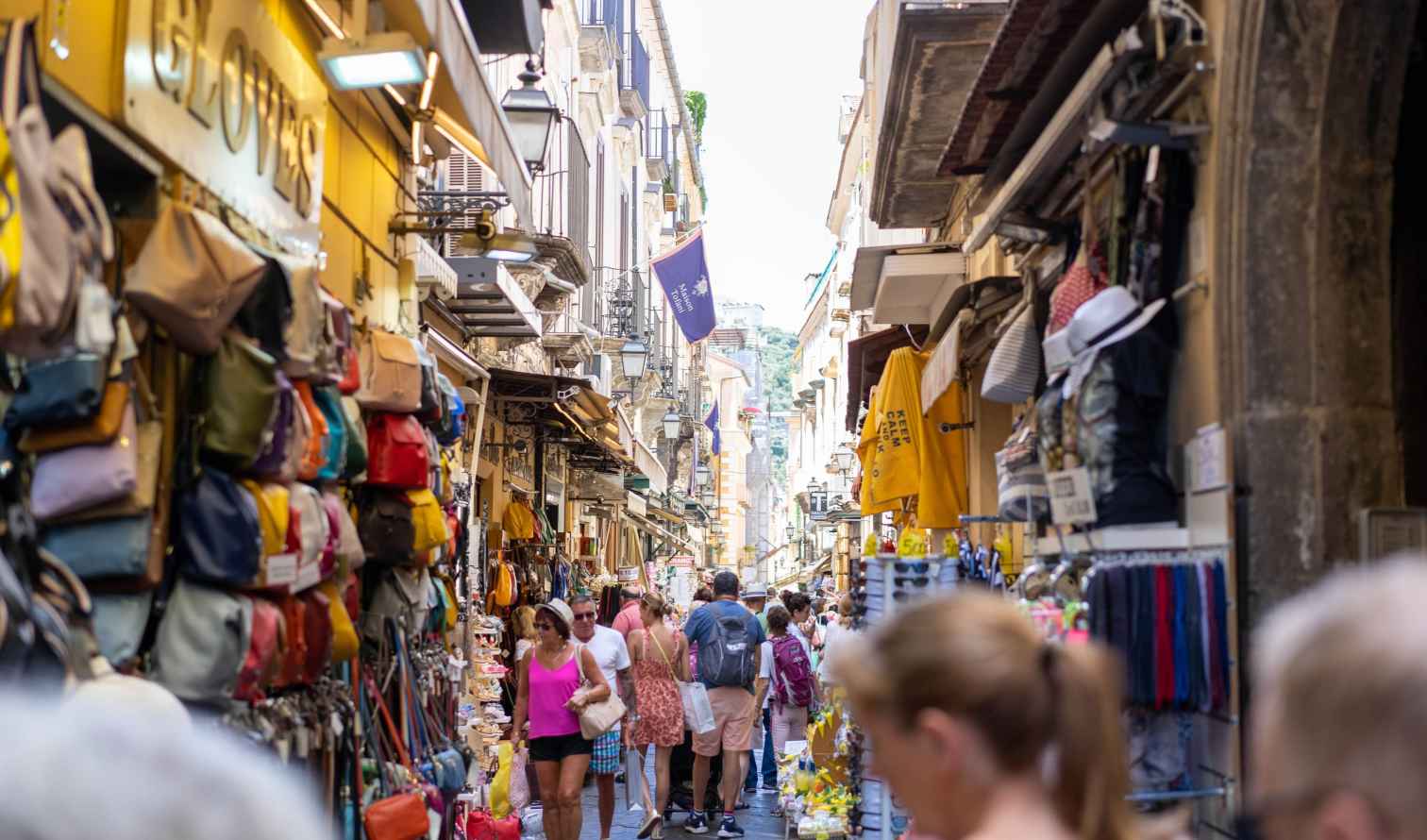A busy street market in Naples, Italy, with shops on both sides.