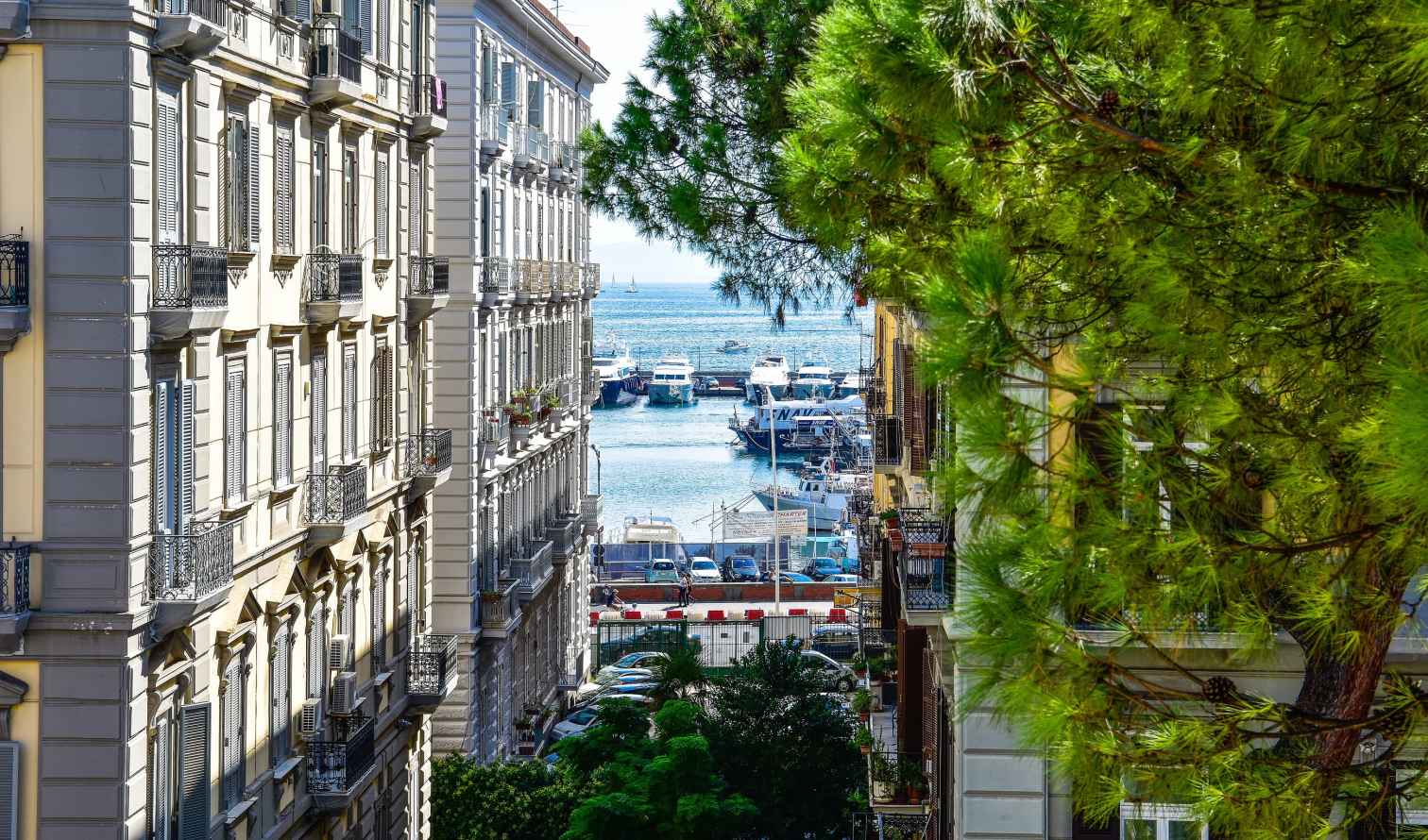 Looking down a residential street towards a busy harbor in Naples.