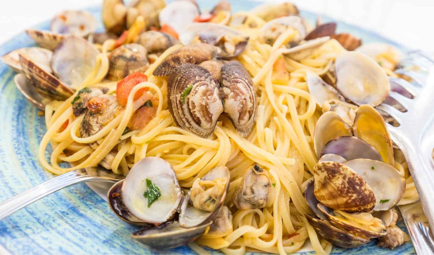 Close-up of spaghetti with clams on a blue plate in Naples