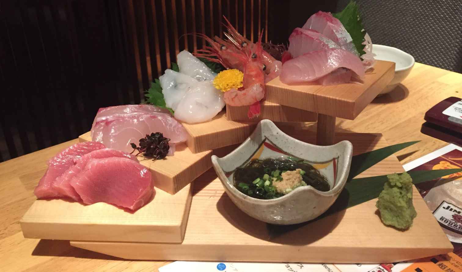 Assorted sashimi on wooden platters at a Japanese restaurant in Kanazawa