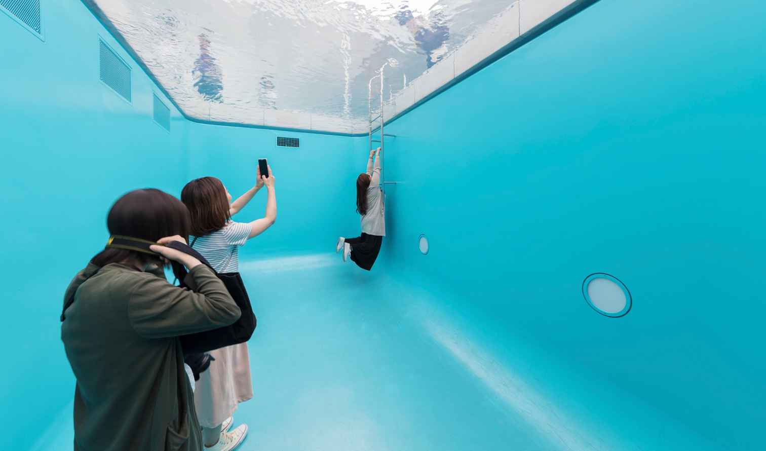 People viewing the art installation 'Swimming Pool' at 21st Century Museum of Contemporary Art in Kanazawa 