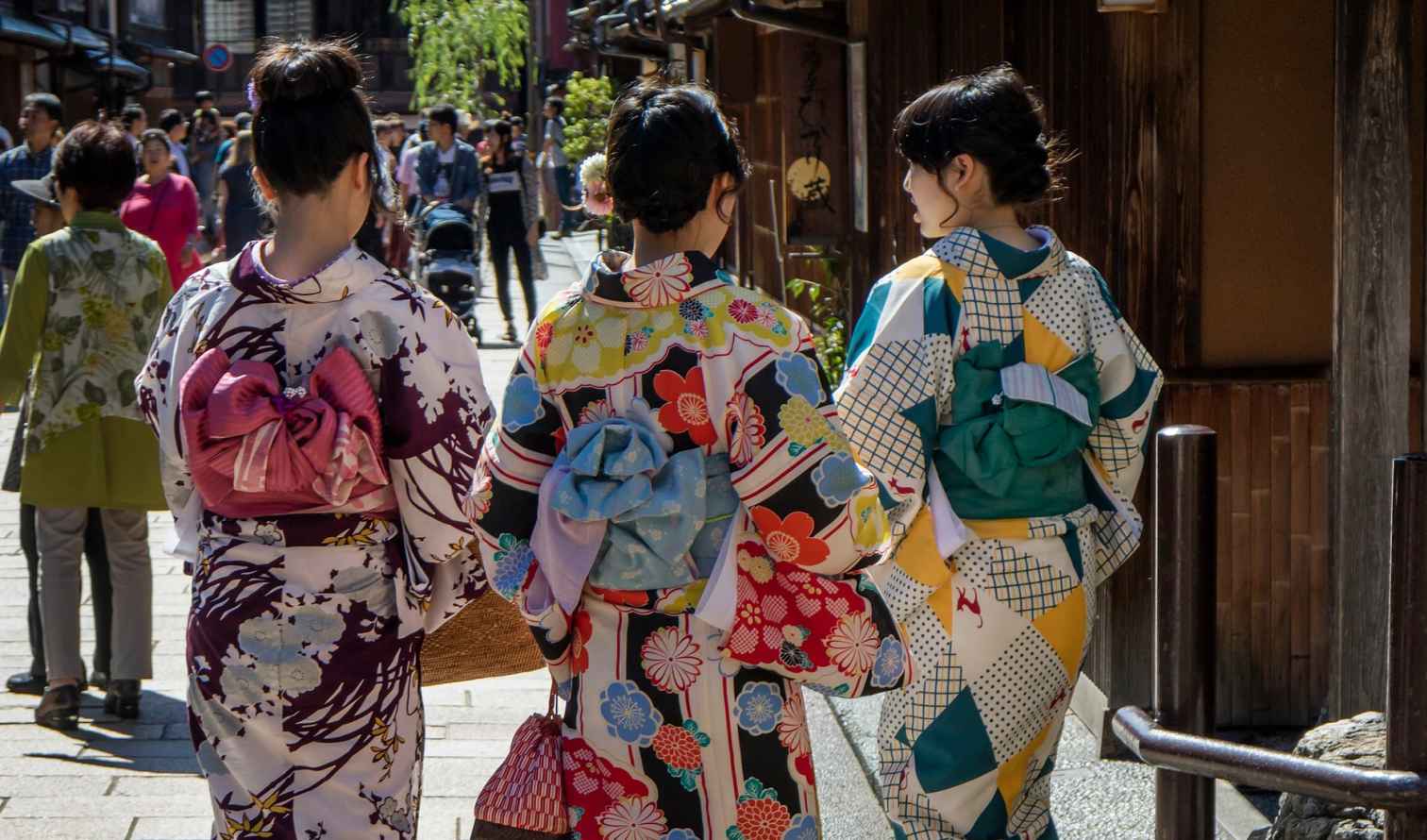 Back view of women wearing colorful kimonos on a traditional Japanese street in Kanazawa