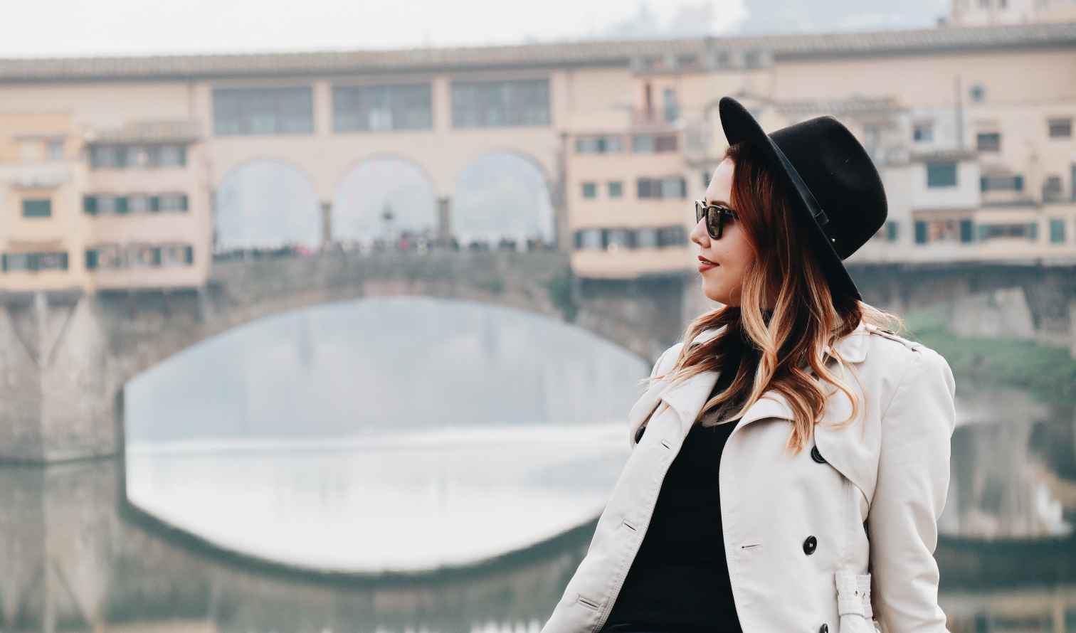 Woman in front of Ponte Vecchio bridge in Florence, Italy.