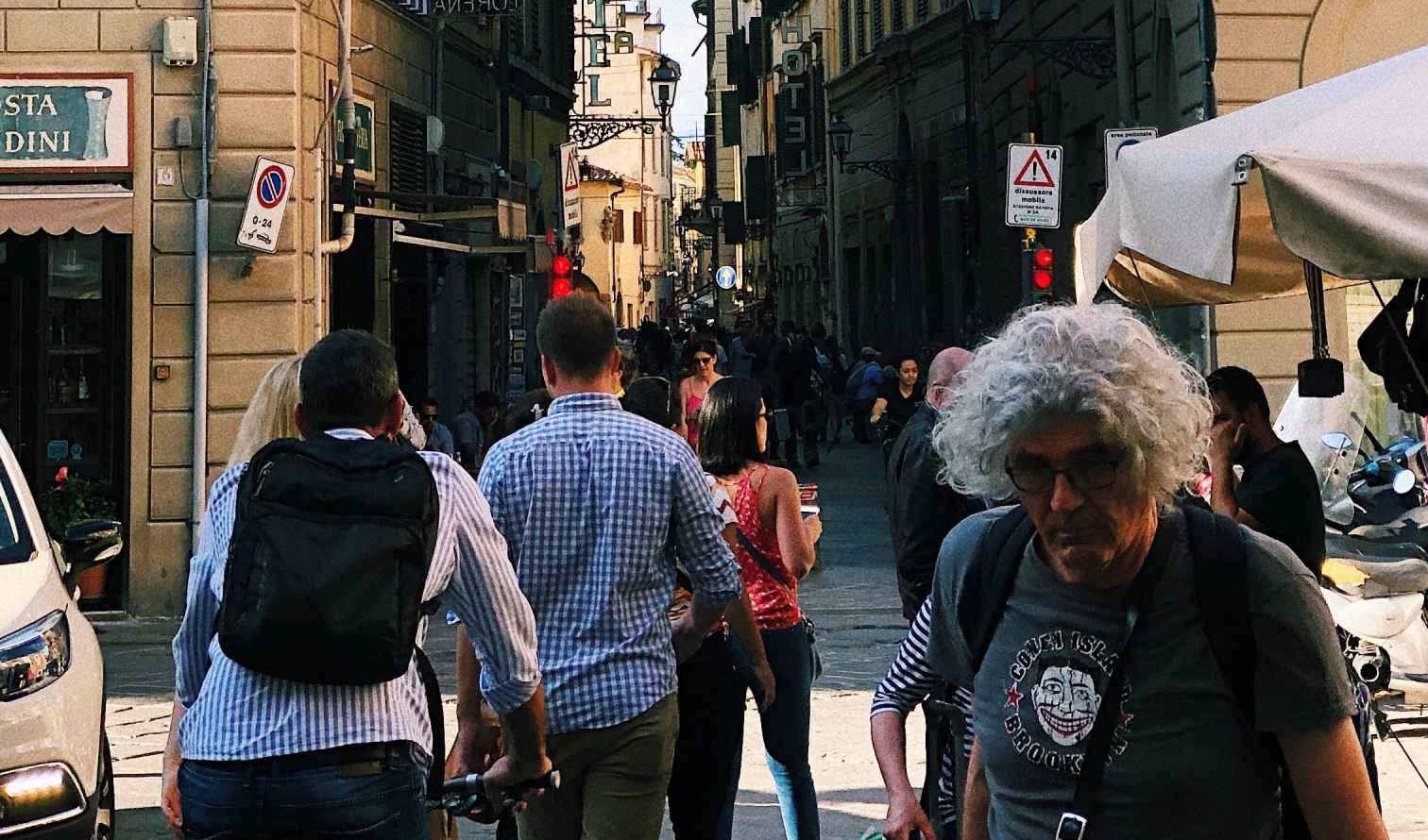 Visitors walk along a busy street in the heart of Florence, Italy.