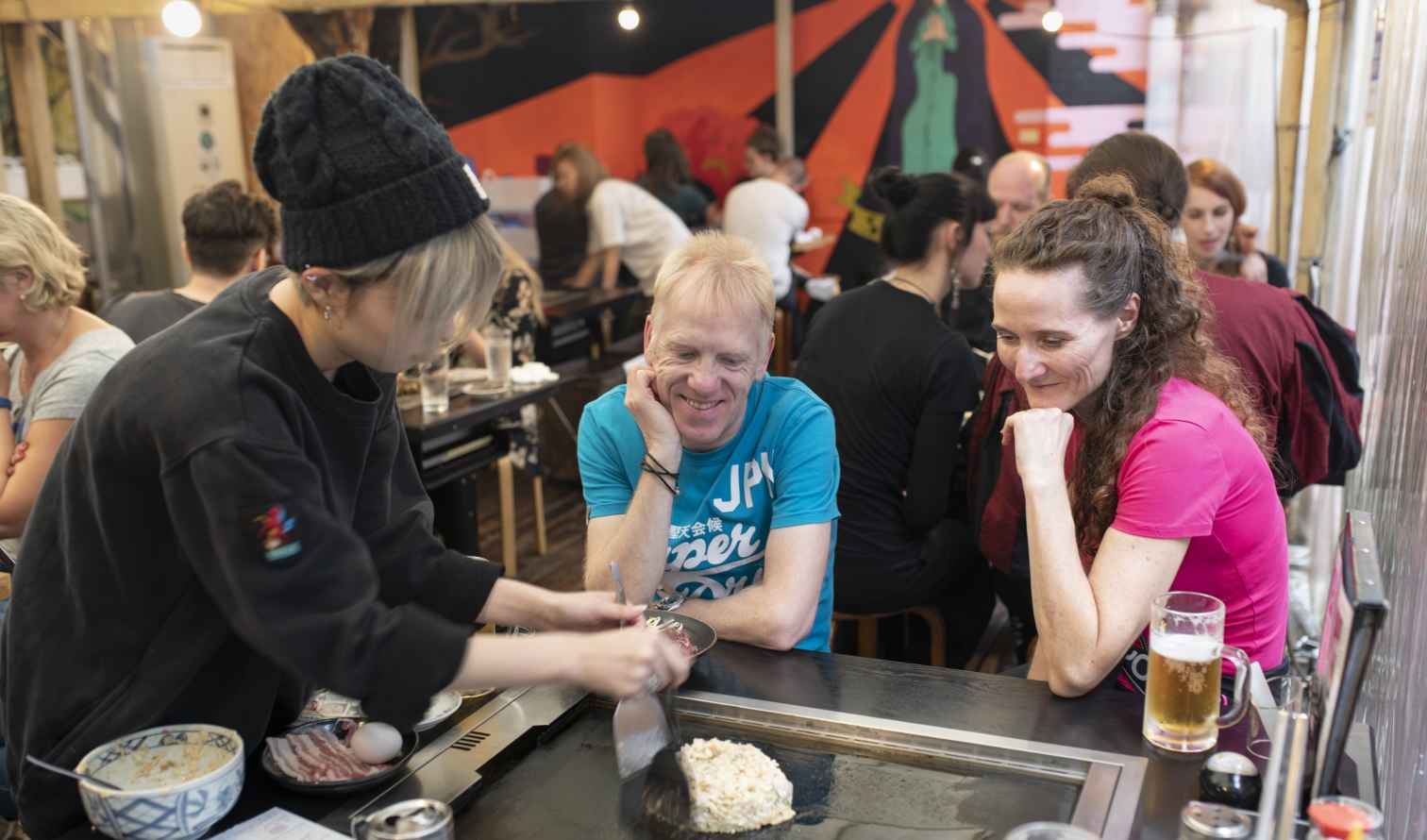 Teppanyaki chef cooking for customers at a communal table in Osaka