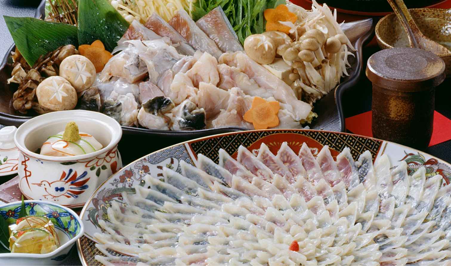 Bowls of Japanese food including mushrooms, tofu, and fish jelly in artistic ceramics in Osaka
