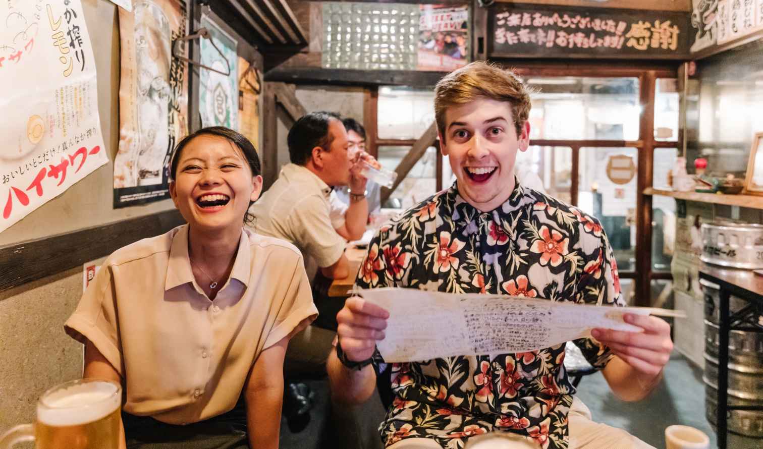 Two people sitting at a table in a Japanese izakaya restaurant in Osaka