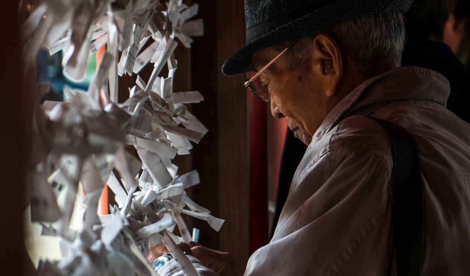 Man tying wishes at a Japanese shrine in Hiroshima