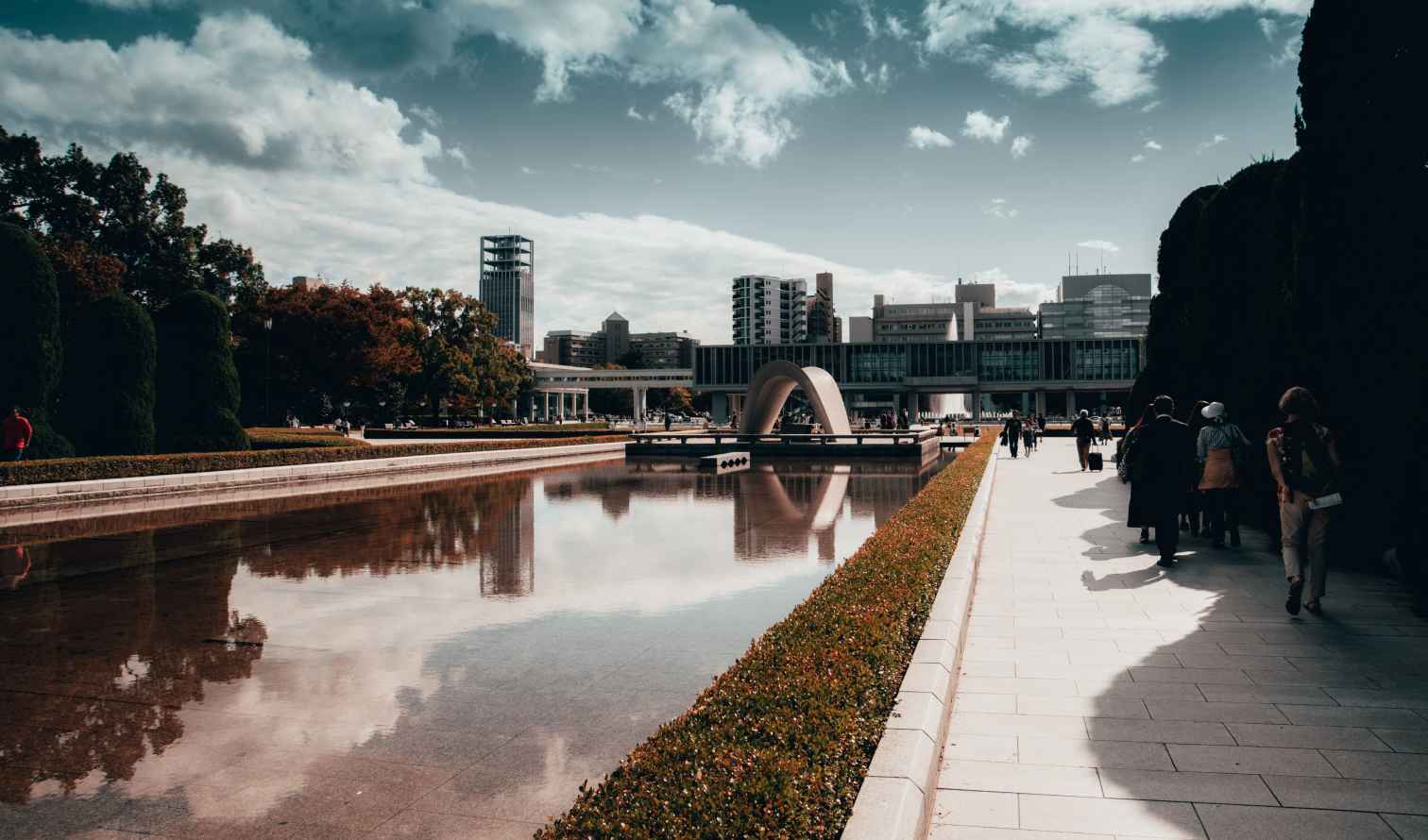Hiroshima Peace Memorial Park with reflection pool and arch-shaped monument.