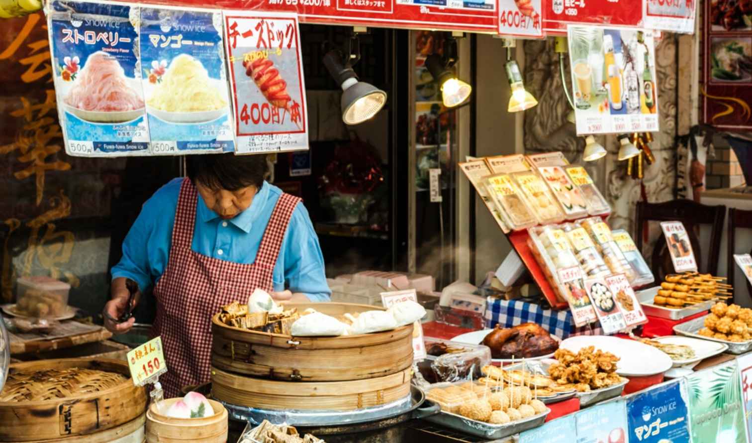 Street vendor selling food in a Japanese market with colorful signs  in Nagasaki 