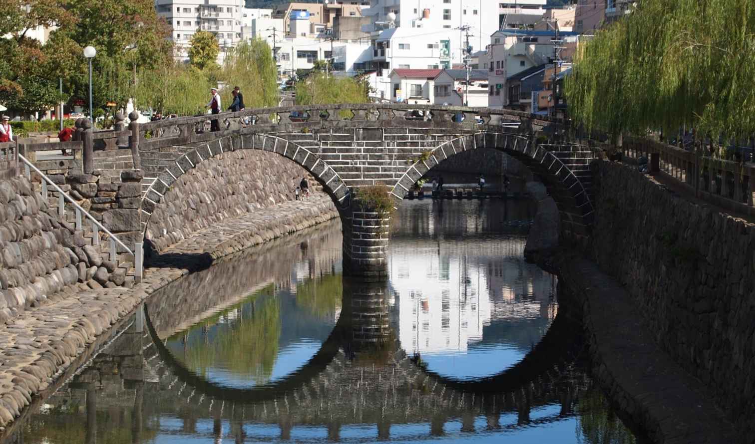 View of Meganebashi Bridge over a calm river in Nagasaki, Japan.