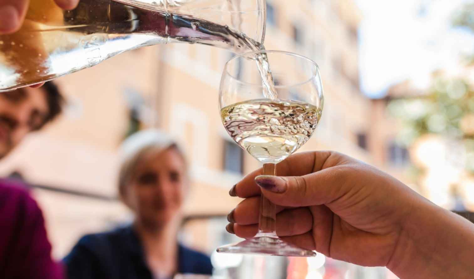 Wine pouring from a carafe with a European street view in Rome