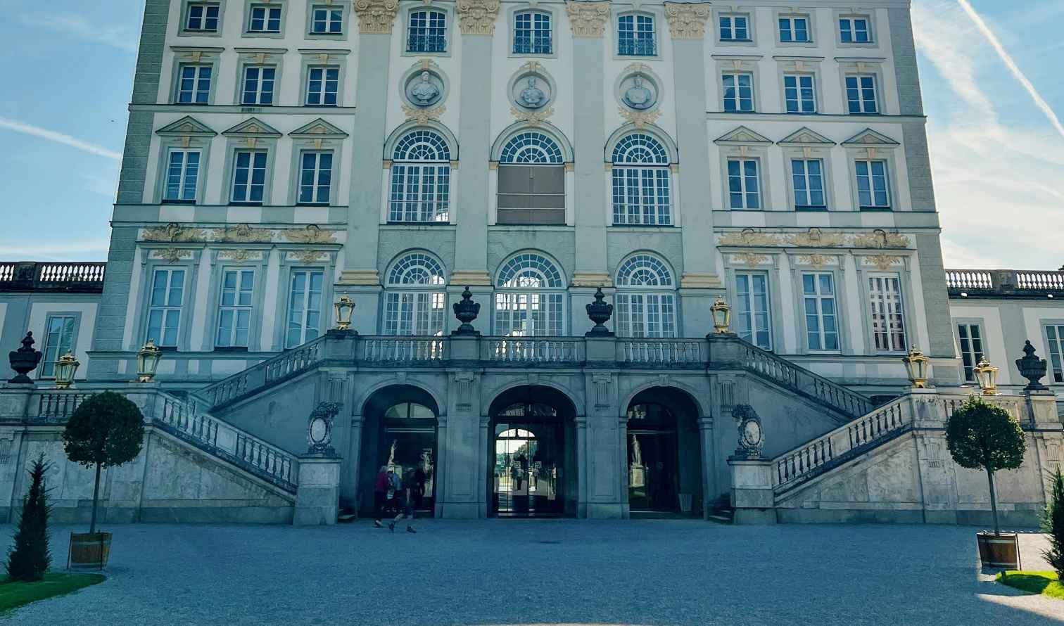 Facade of Schloss Lustheim in Munich with clear sky and contrails.