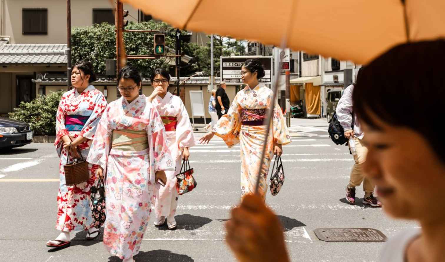 Women in kimonos crossing a street in Kyoto, Japan.
