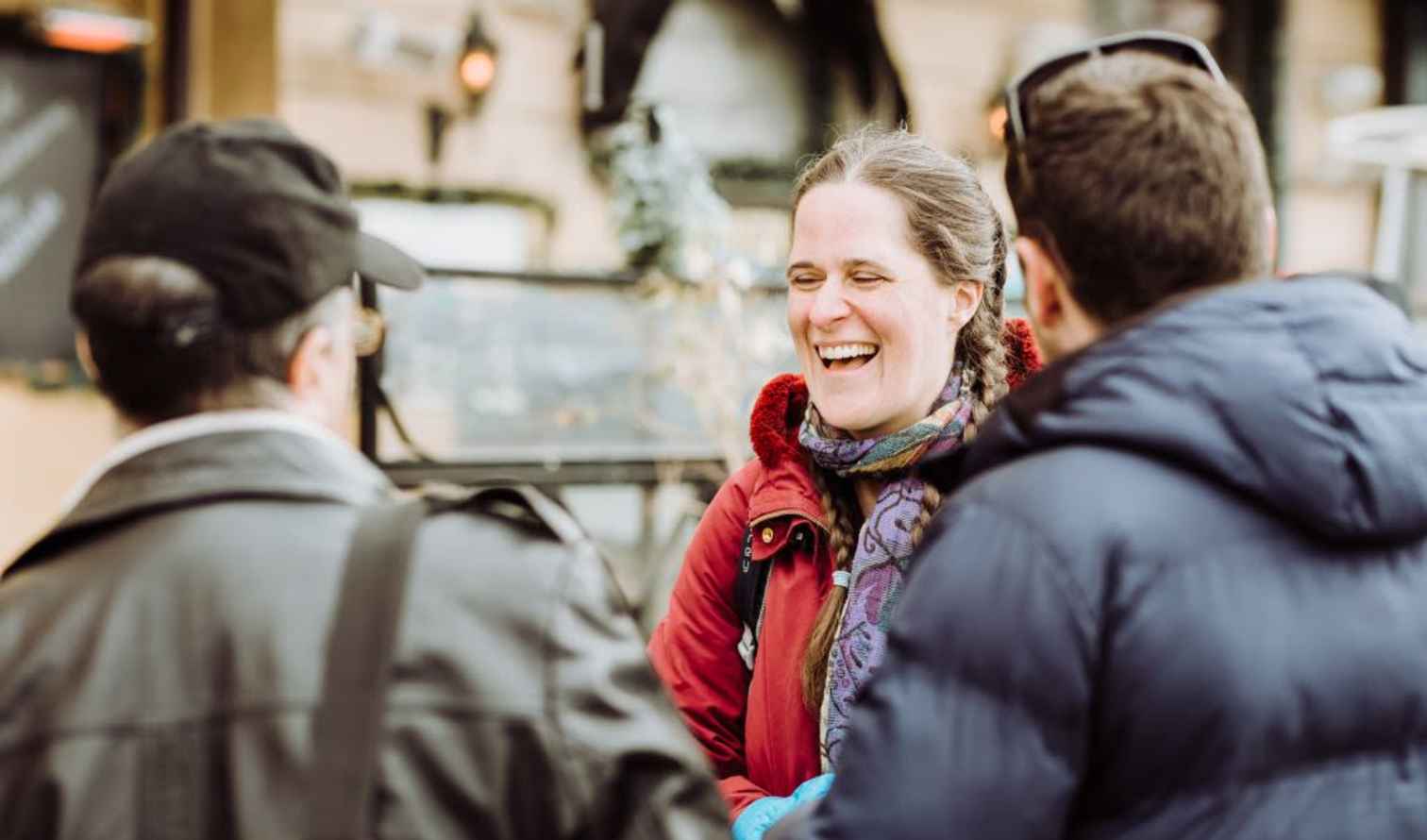 Three people talking outside in a cafe setting in Stockholm