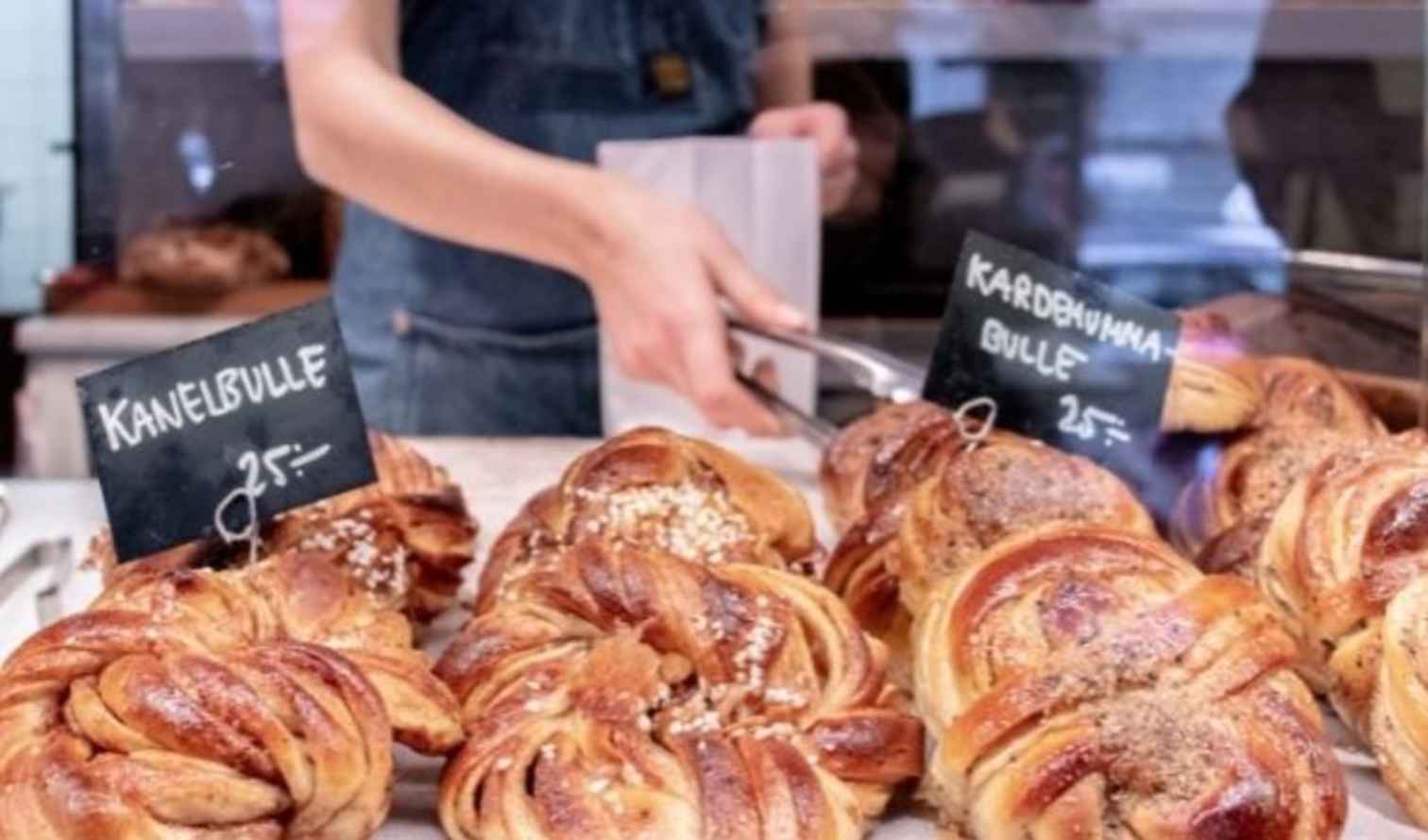Close-up of Swedish pastry counter with labeled kanelbulle and kardemummabulle pastries in Stockholm