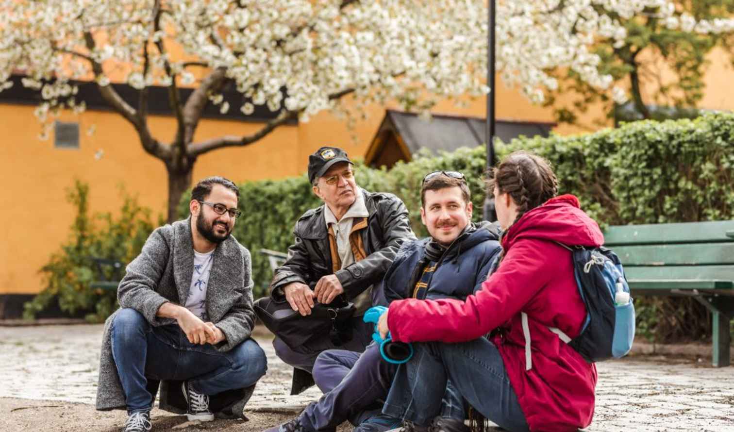 Four people sitting in a courtyard on Gotland Street, Stockholm.