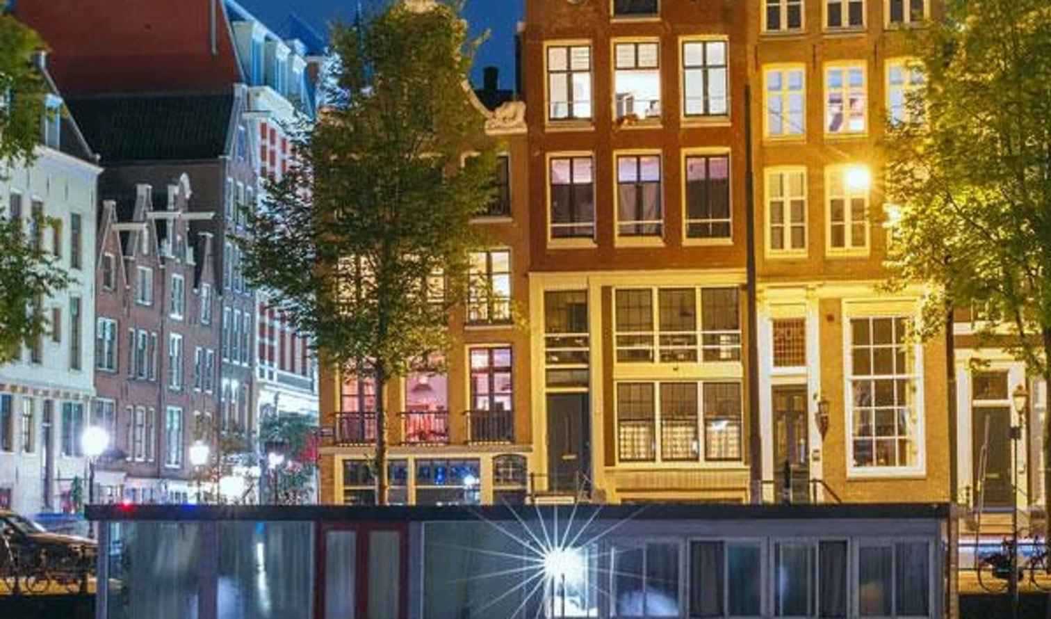 Traditional Dutch canal houses along the Herengracht in Amsterdam at night.