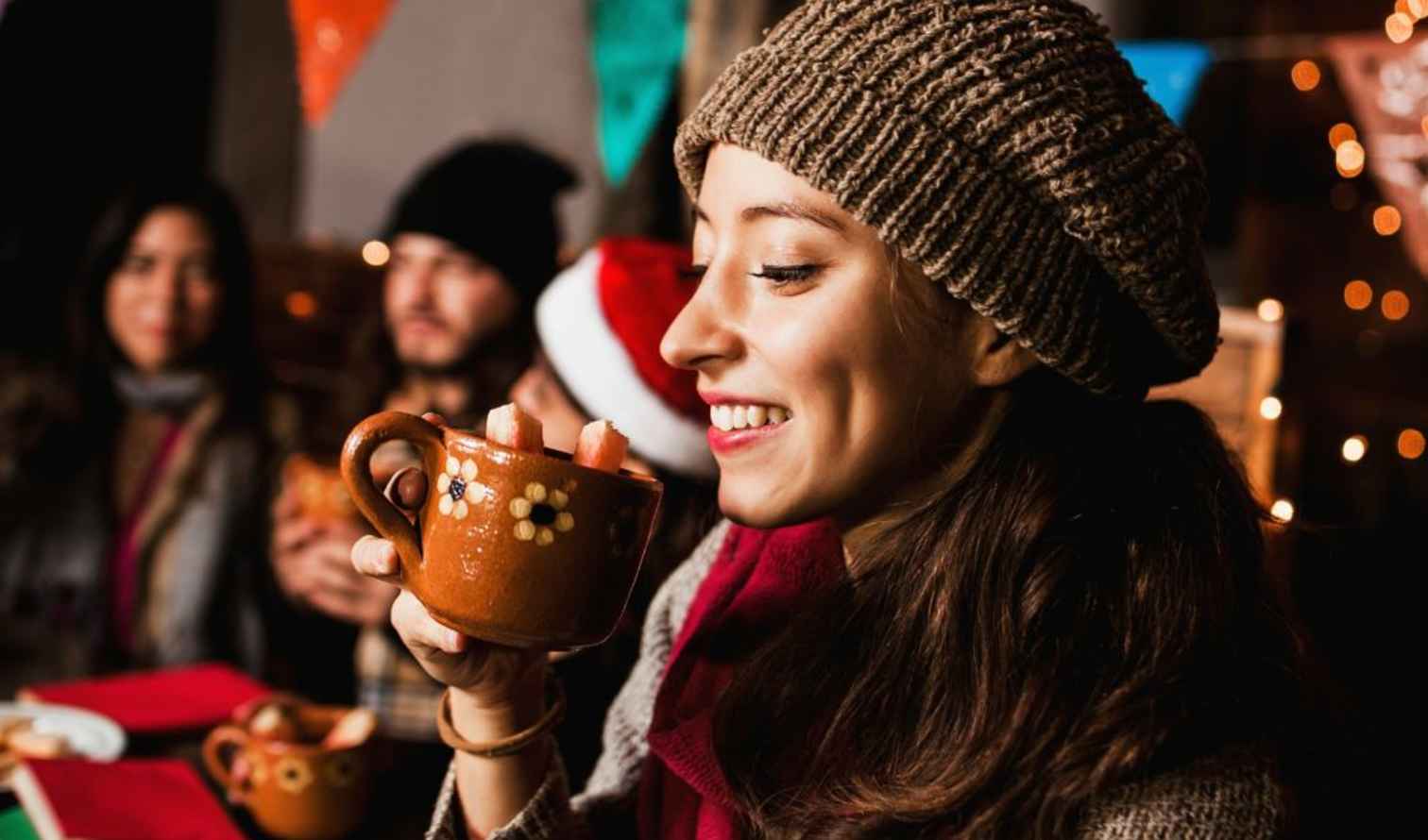 Woman holding a decorated mug at a festive gathering in Mexico